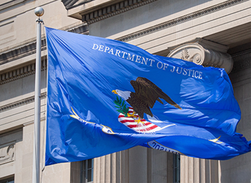 The U.S. Justice Department flag flies outside the department's main headquarters in Washington, D.C.