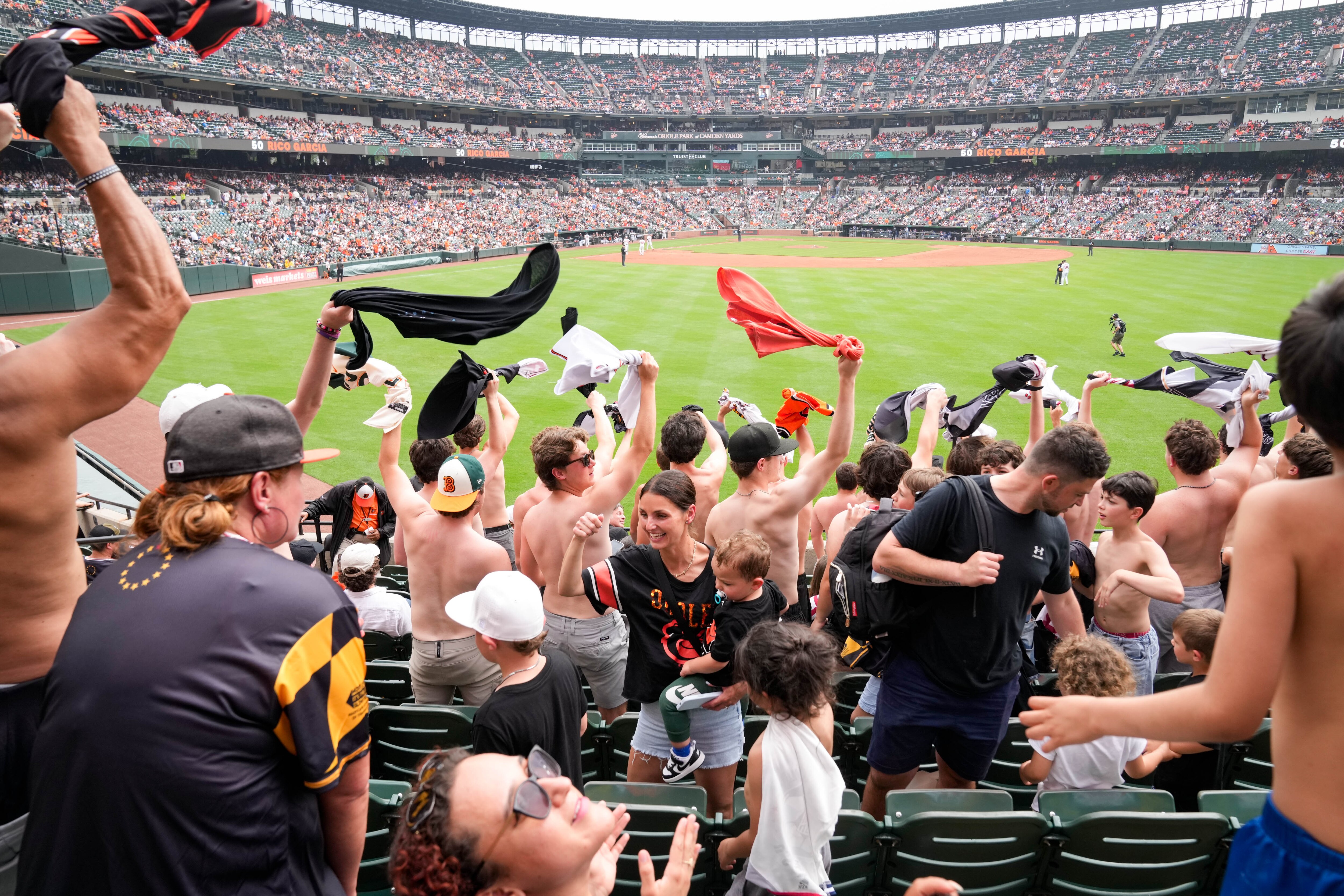 Shirtless “Tarps Off” fans wave their shirts over their heads from center field during the eighth inning of a game between the Baltimore Orioles and the Tampa Bay Rays at Camden Yards in May.