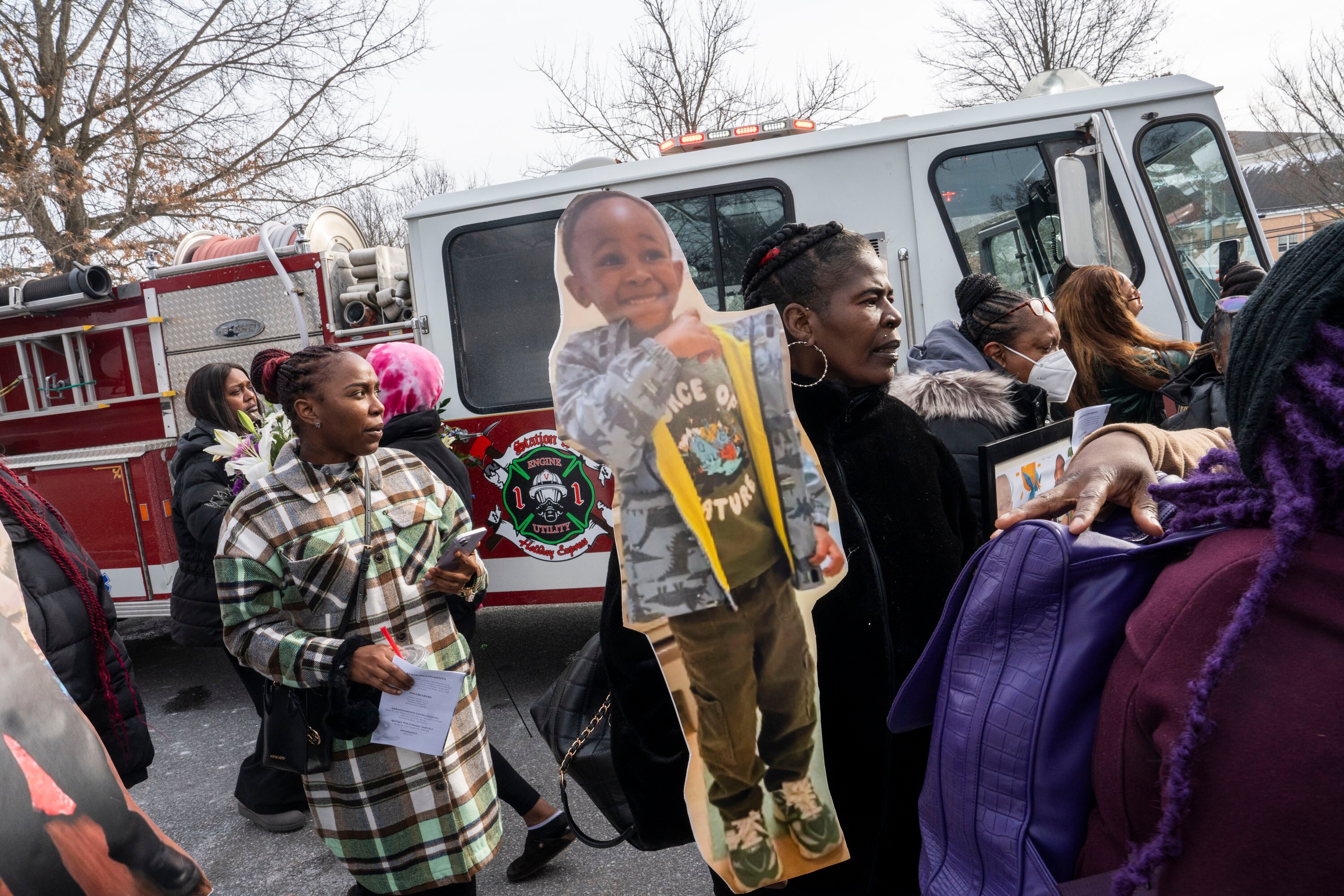 Angela Christie carries a cardboard cutout of 4-year-old Jacobi Marcelle during his funeral on Friday. Her granddaughter, Denaja Johnson, 4, was one of the boy's best friends.