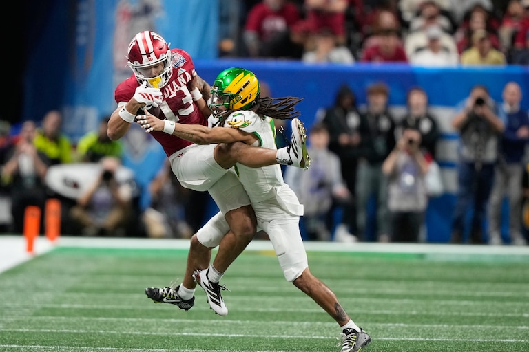Indiana wide receiver Elijah Sarratt (13) pulls in a pass over Oregon defensive back Theran Johnson (5) during the first half of the Peach Bowl NCAA college football playoff semifinal, Friday, Jan. 9, 2026, in Atlanta. (AP Photo/Brynn Anderson)