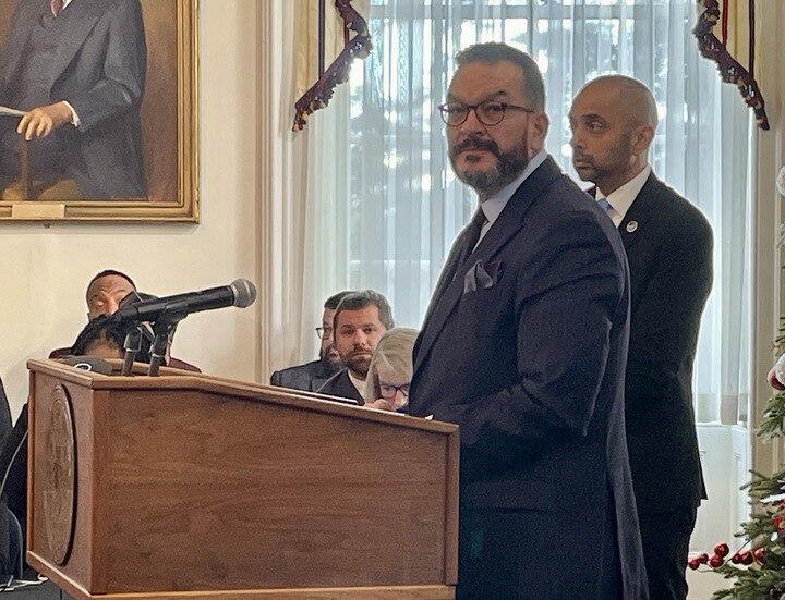 Department of Human Services Secretary Rafael Lopez stands before a podium at the Board of Public Works meeting on Dec. 18, 2024.