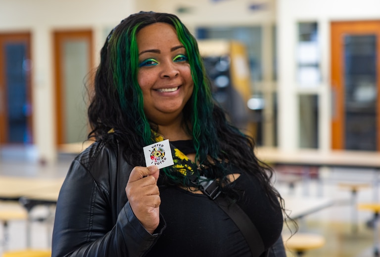 Kia-Michelle Massey proudly shows off her “I voted” sticker on Nov. 8, 2022 after submitting her ballot at Dunbar High School in Baltimore.