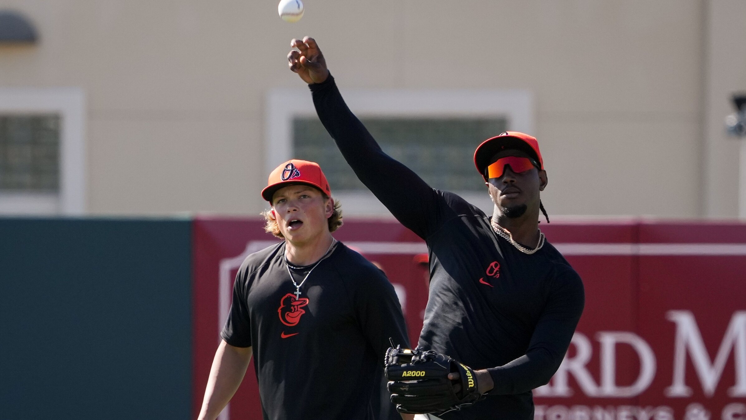 Baltimore Orioles shortstop Jorge Mateo, right, throws next to prospect Jackson Holliday during the team’s spring training session at Ed Smith Stadium on February 23, 2024.
