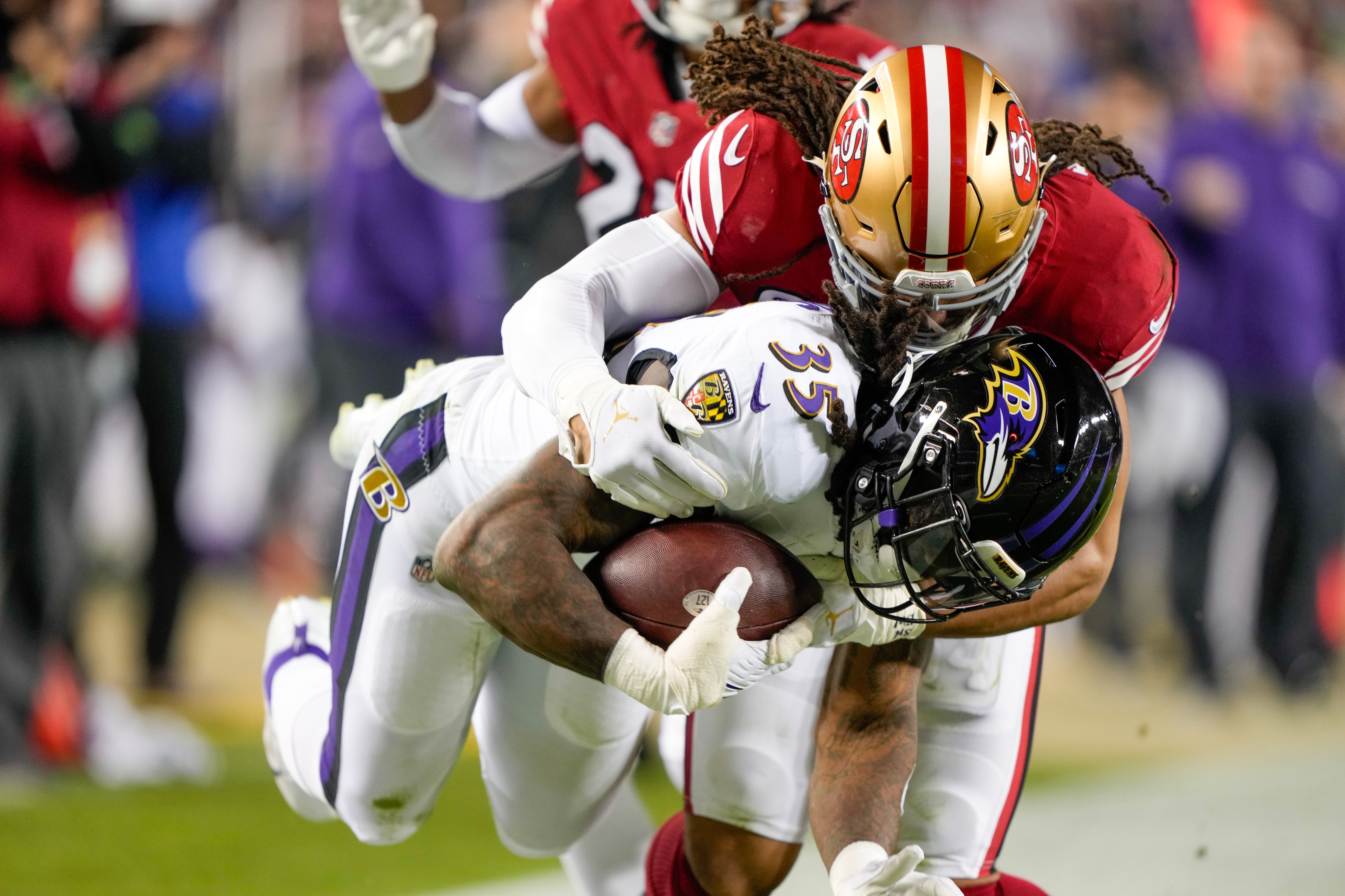 Fred Warner #54 of the San Francisco 49ers tackles Gus Edwards #35 of the Baltimore Ravens during the third quarter at Levi's Stadium on December 25, 2023 in Santa Clara, California.