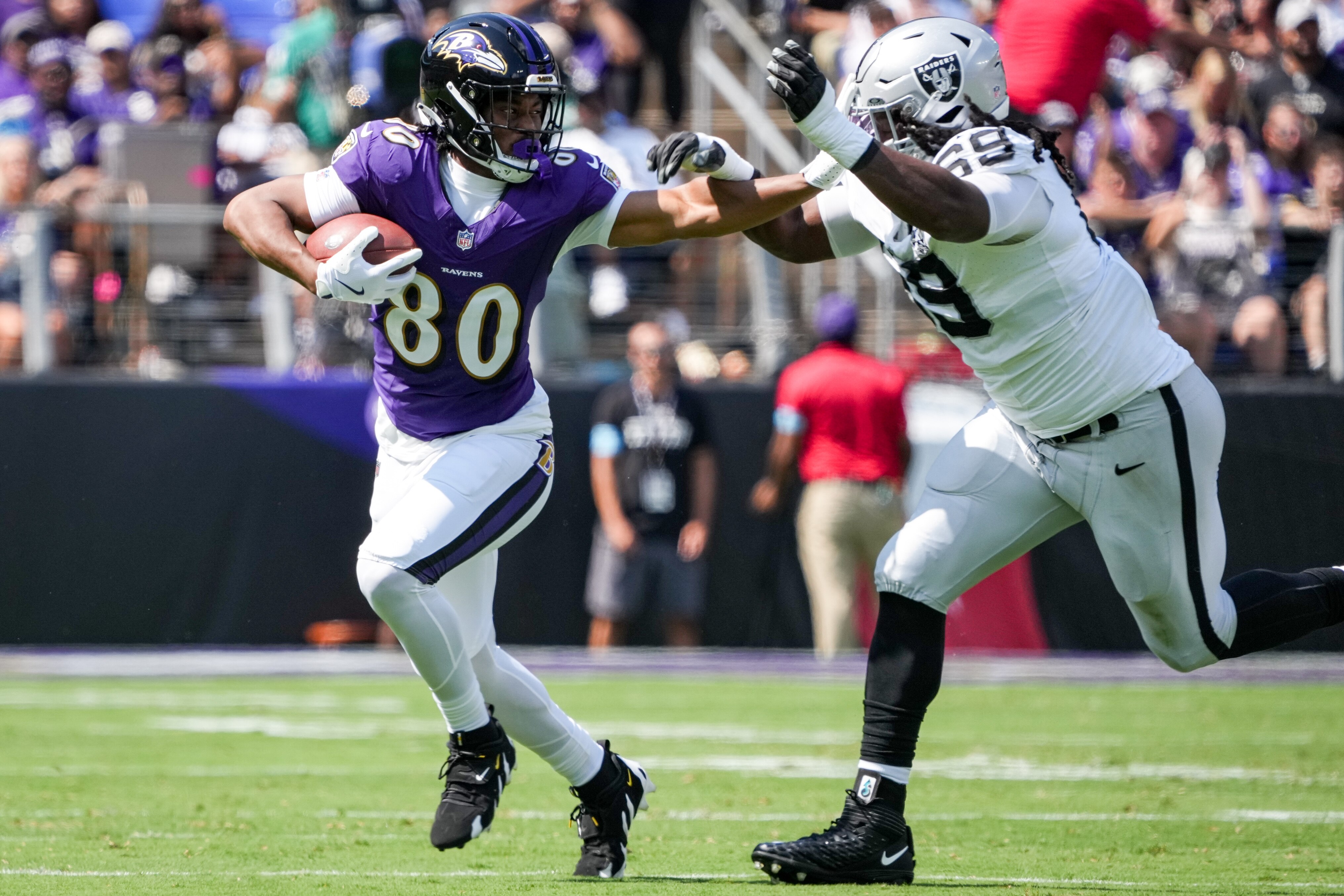 Baltimore Ravens tight end Isaiah Likely (80) stiff arms Las Vegas Raiders defensive tackle Adam Butler (69) during a game at M&T Bank Stadium in Baltimore on Sunday, September 15, 2024.