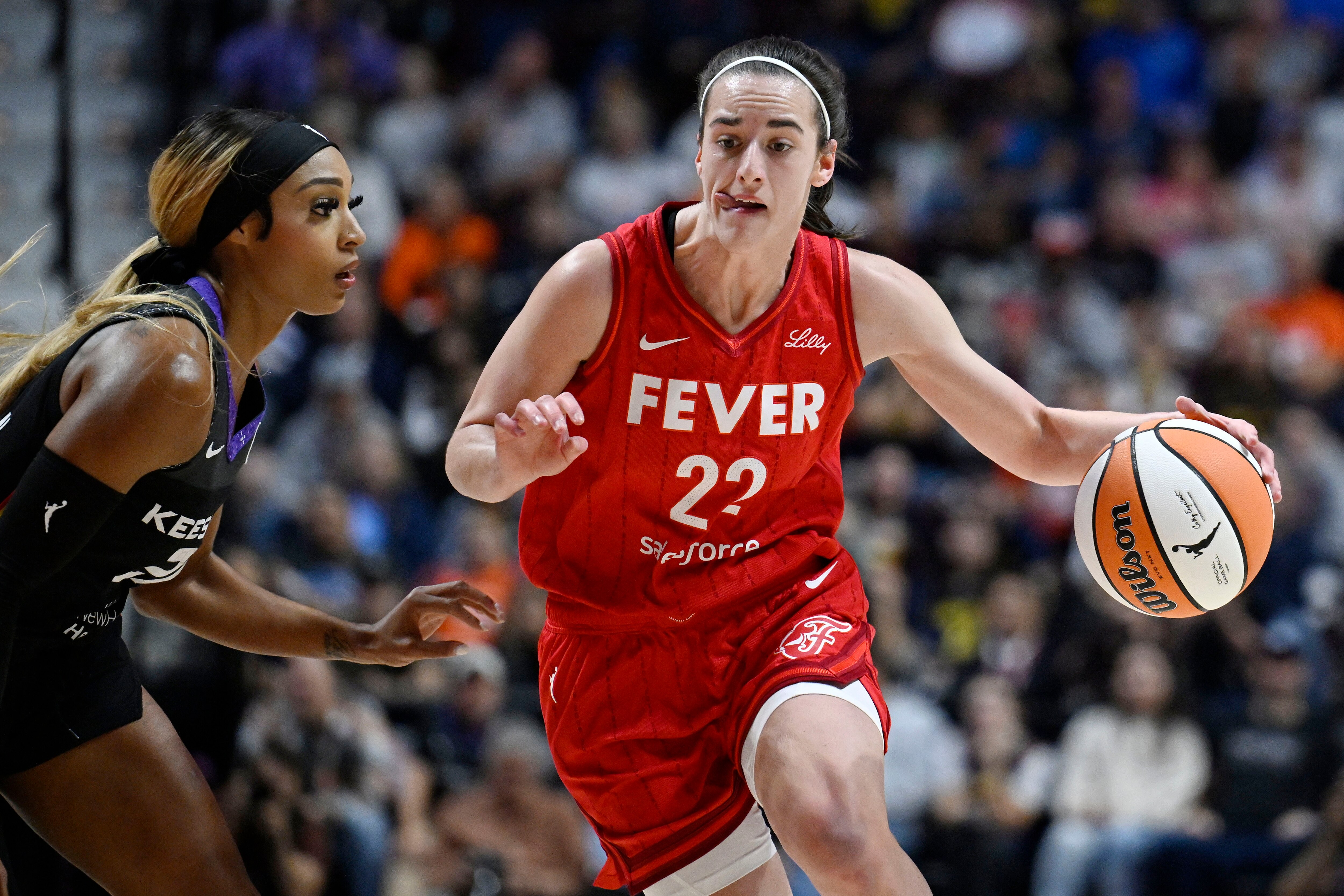 Indiana Fever guard Caitlin Clark drives to the basket as Connecticut Sun guard DiJonai Carrington defends during the playoffs.