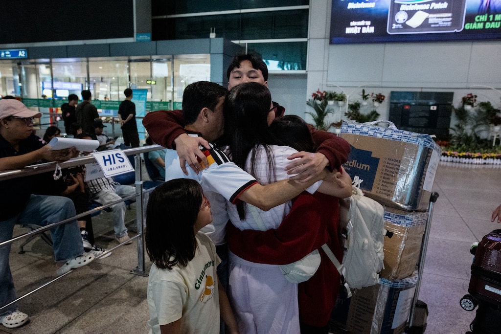 Ho Chi Minh, Vietnam - Aug 5, 2026: Danny Hoang, 56, and Melissa Tran, 44, hug their children at Tan Son Nhat International Airport in Ho Chi Minh, Vietnam on August 5, 2026. Rosem Morton for The Baltimore Banner