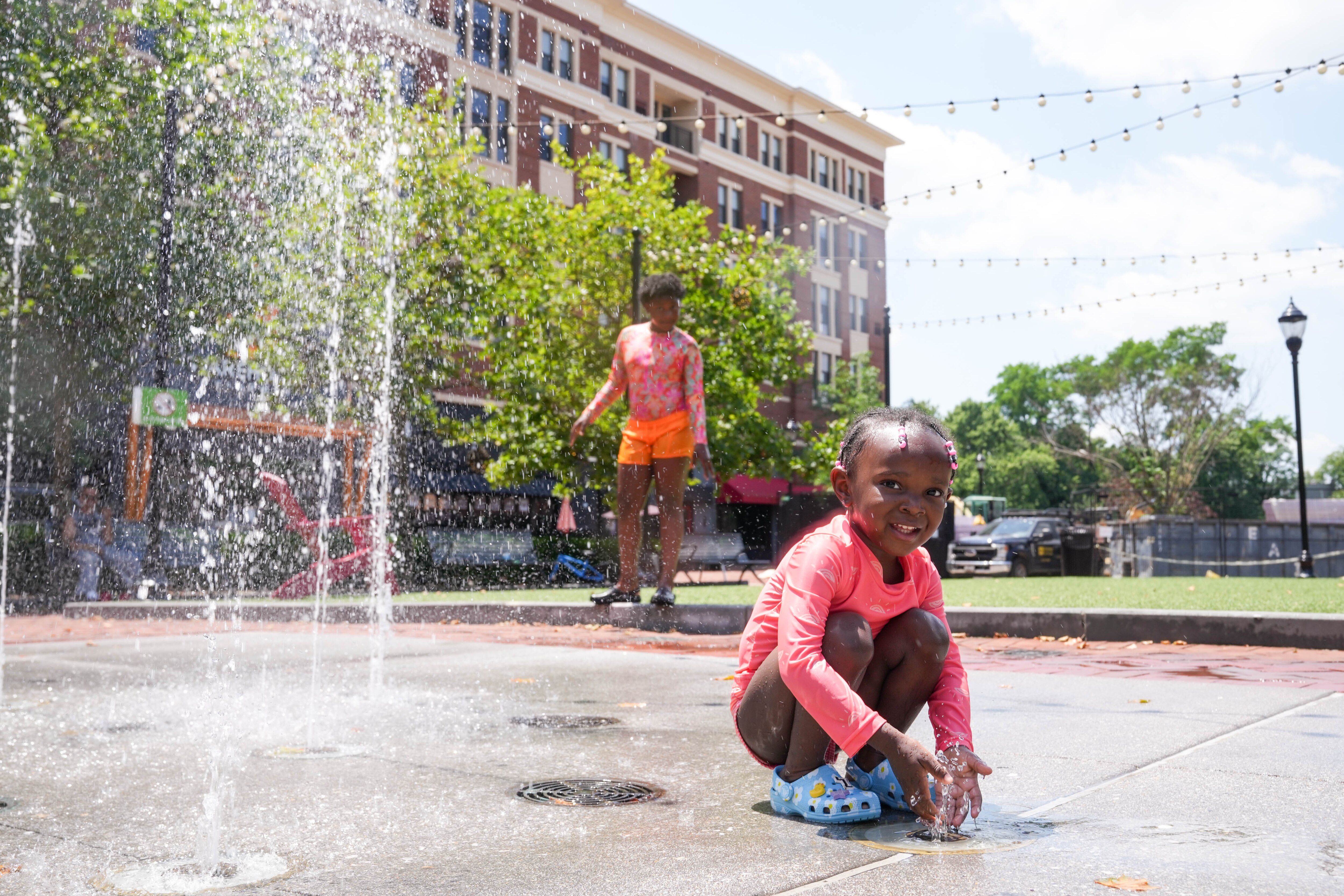 Kids play at the splash pad at the Rotunda in June 2025. The Hampden shopping center hosts a free, family-friendly concert series on Friday evenings through Oct. 3.