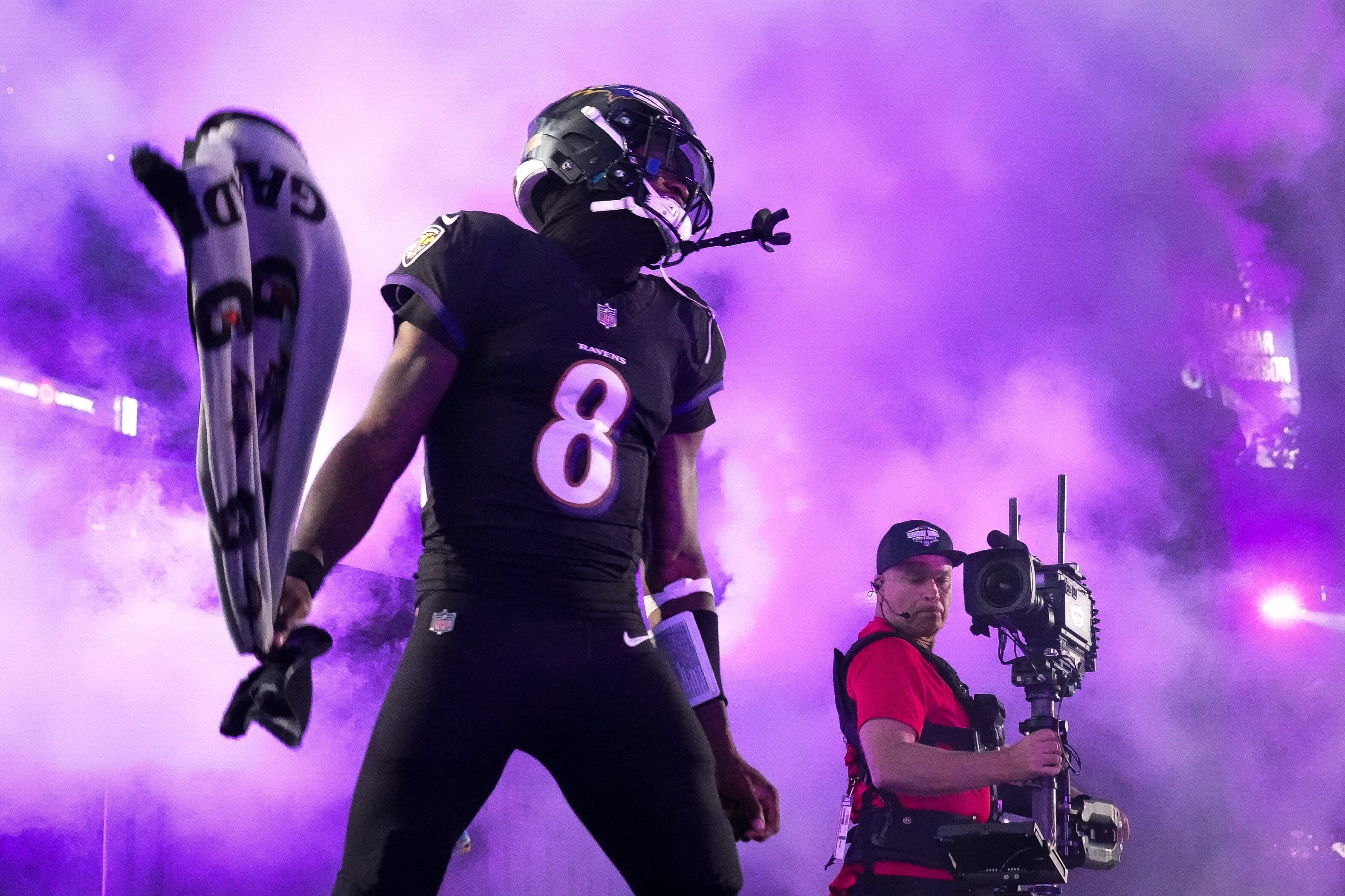 Baltimore Ravens quarterback Lamar Jackson (8) waves his towel through the smoke during his introduction before a game against the Buffalo Bills.