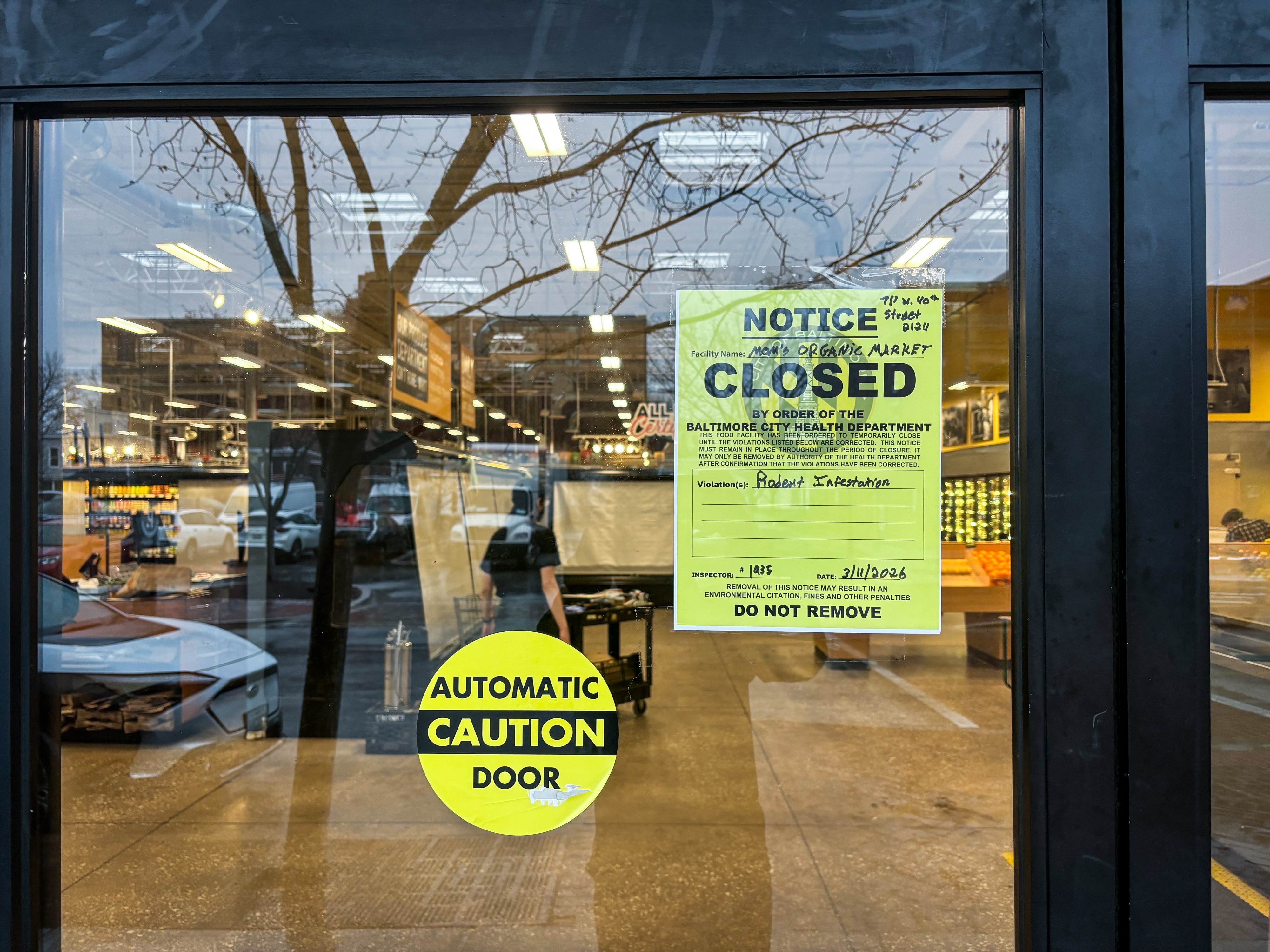 A sign in the door of Mom's Organic Market at the Rotunda in Baltimore's Hampden neighborhood shows a notice the shop was closed for a rodent infestation.