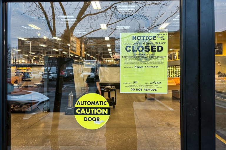 A sign in the door of Mom's Organic Market at the Rotunda in Baltimore's Hampden neighborhood shows a notice the shop was closed for a rodent infestation.