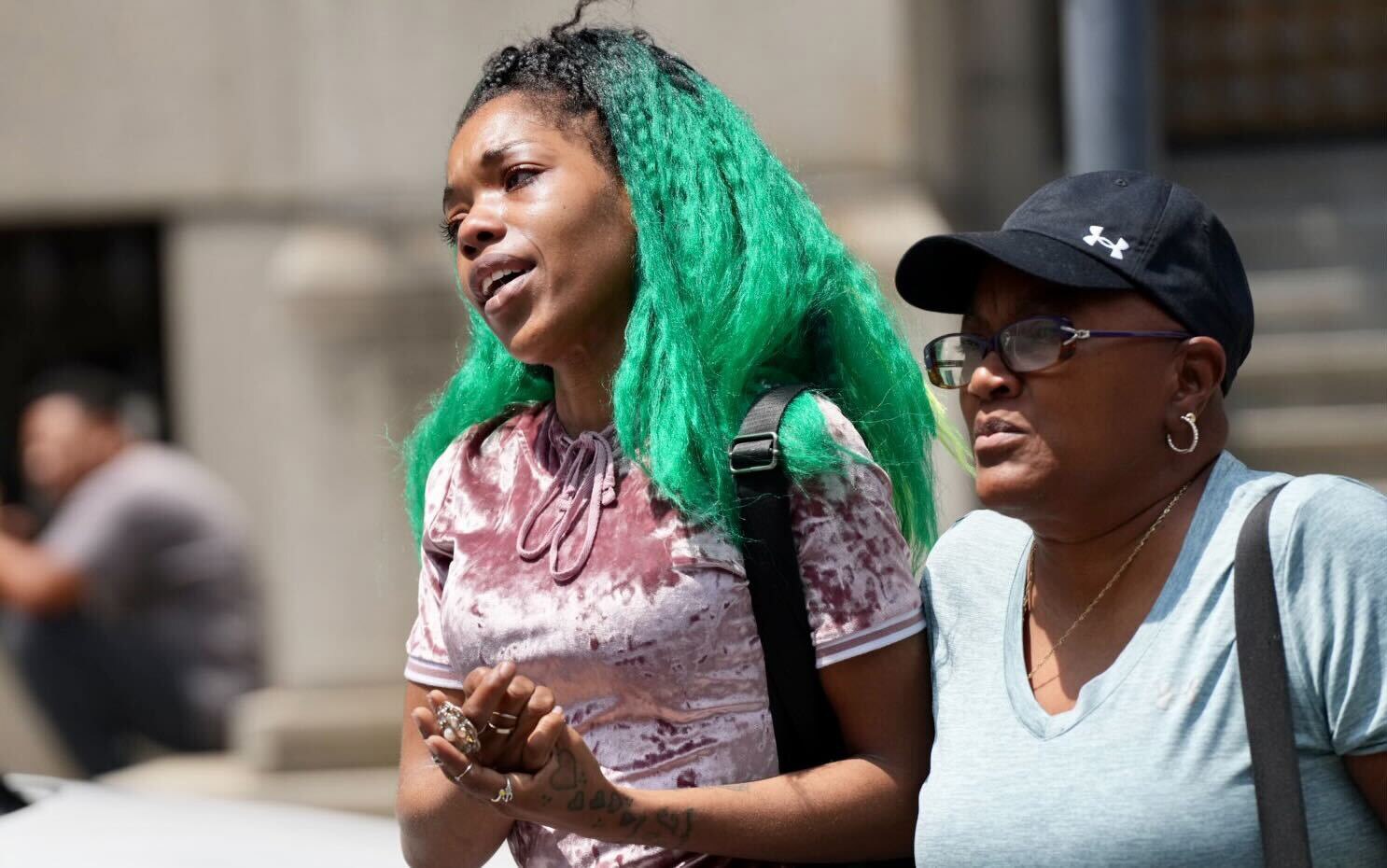 Aijah Gatson, left, the mother of a 16-year-old found guilty of voluntary manslaughter for shooting and killing Timothy Reynolds on July 7, 2022, leaves the Clarence M. Mitchell Jr. Courthouse in Baltimore on Thursday after a jury returned a verdict in her son’s trial. The jury found him not guilty of first- and second-degree murder.