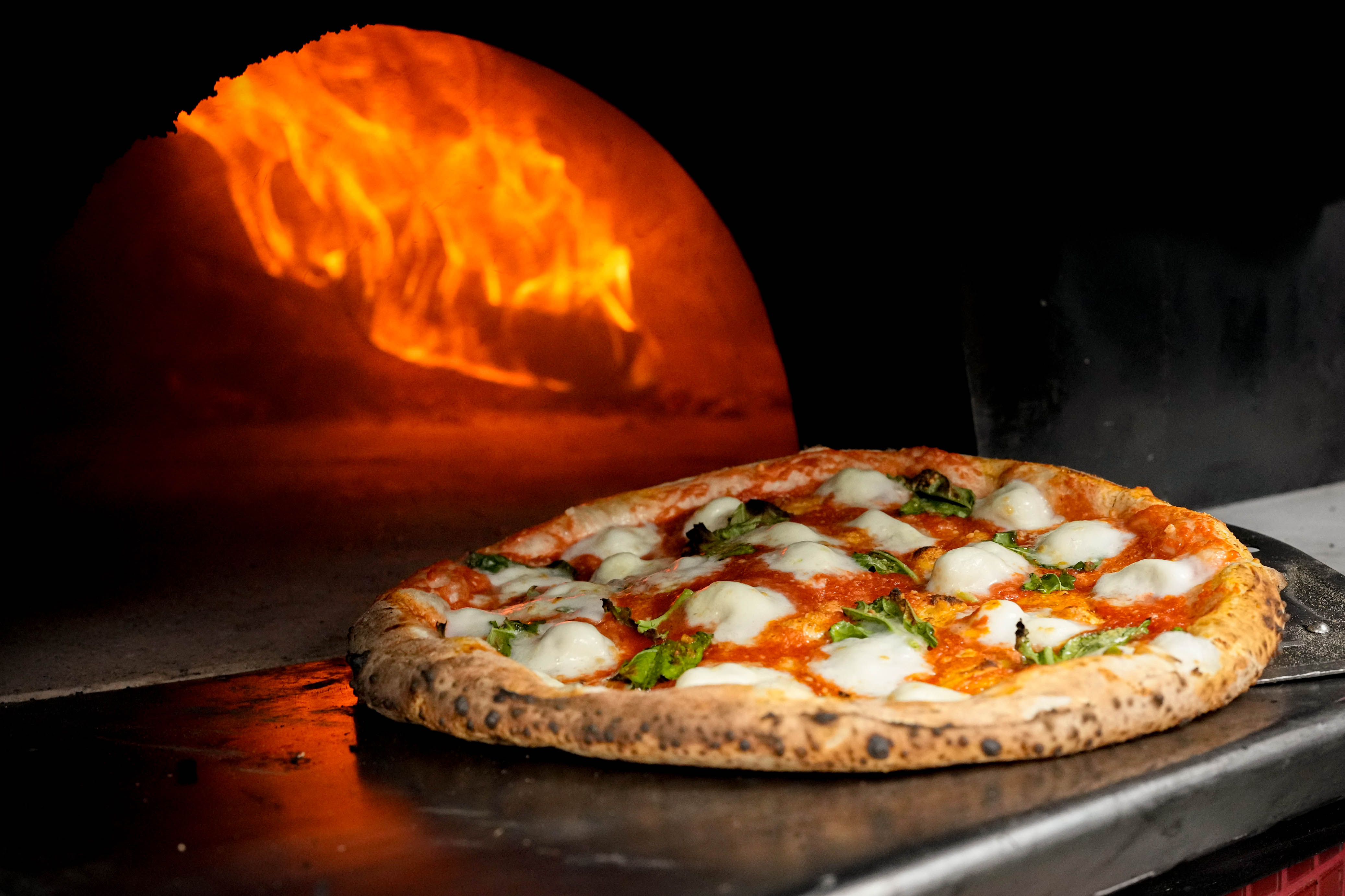 A Margherita pizza is removed from the oven at Pupatella Neapolitan Pizza in Columbia, Md. on Thursday, March 27, 2025. The restaurant is Maryland's first pizzeria to be awarded the Verace Pizza Association certification from the Assozione Verace Pizza Napoletana (AVPN).