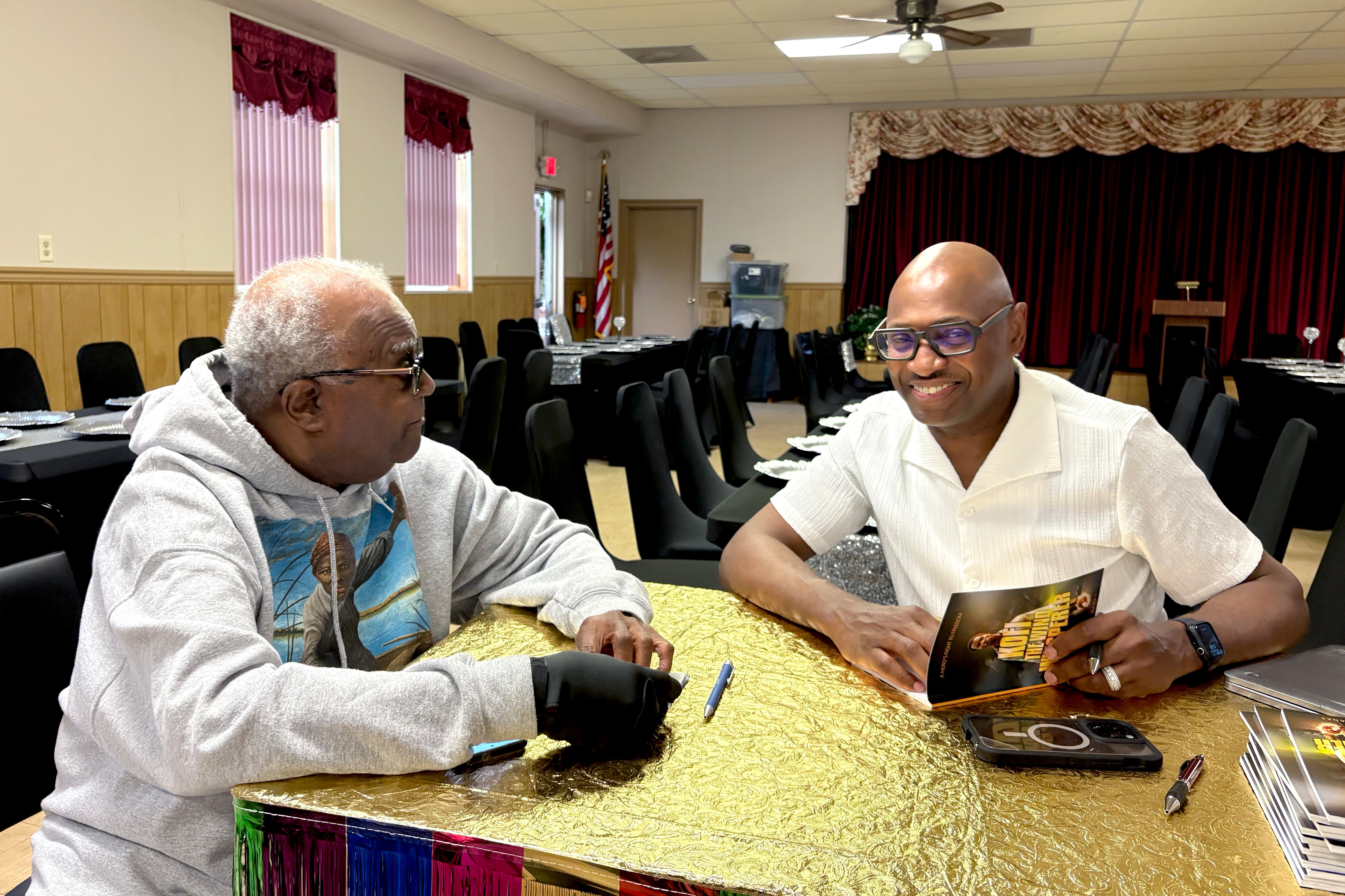 William Jarmon, left, talks with Dion Banks at Banks' book signing on May 29, 2025, in Cambridge.