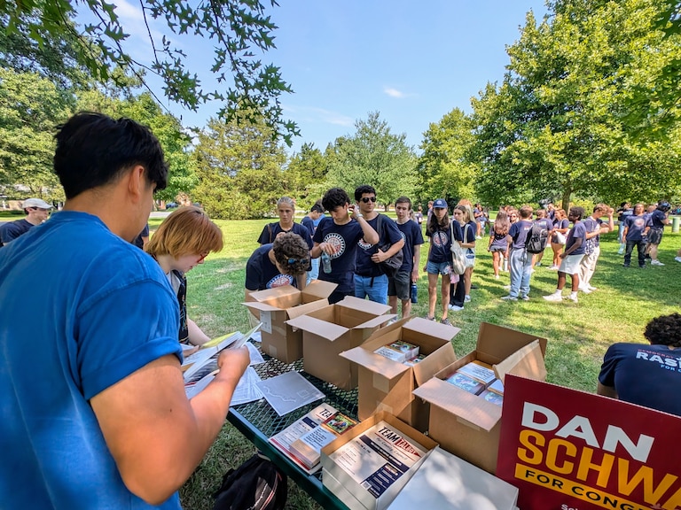Students with Democracy Summer, a youth politics and government program founded by U.S. Rep. Jamie Raskin, line up for canvassing materials to help Dan Schwartz's campaign for Congress.