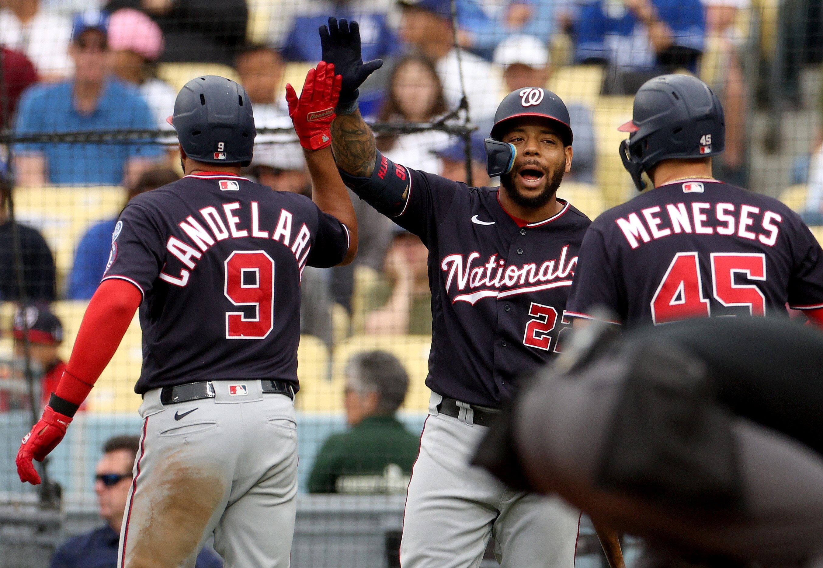LOS ANGELES, CALIFORNIA - MAY 31: Dominic Smith #22 of the Washington Nationals celebrates the two run homerun of Jeimer Candelario #9 with Joey Meneses #45, to take a 5-4 lead over the Los Angeles Dodgers, during the fifth inning at Dodger Stadium on May 31, 2023 in Los Angeles, California.