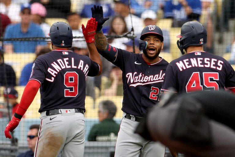 LOS ANGELES, CALIFORNIA - MAY 31: Dominic Smith #22 of the Washington Nationals celebrates the two run homerun of Jeimer Candelario #9 with Joey Meneses #45, to take a 5-4 lead over the Los Angeles Dodgers, during the fifth inning at Dodger Stadium on May 31, 2023 in Los Angeles, California.