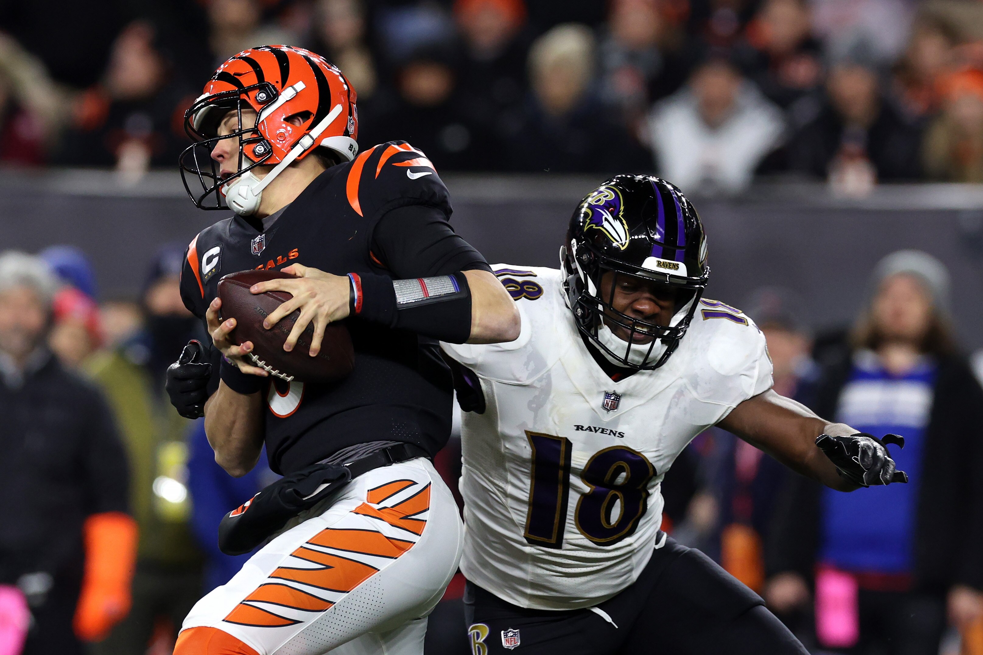 Quarterback Joe Burrow #9 of the Cincinnati Bengals eludes the tackle of linebacker Roquan Smith #18 of the Baltimore Ravens during the AFC Wild Card playoff game at Paycor Stadium on January 15, 2023 in Cincinnati, Ohio.