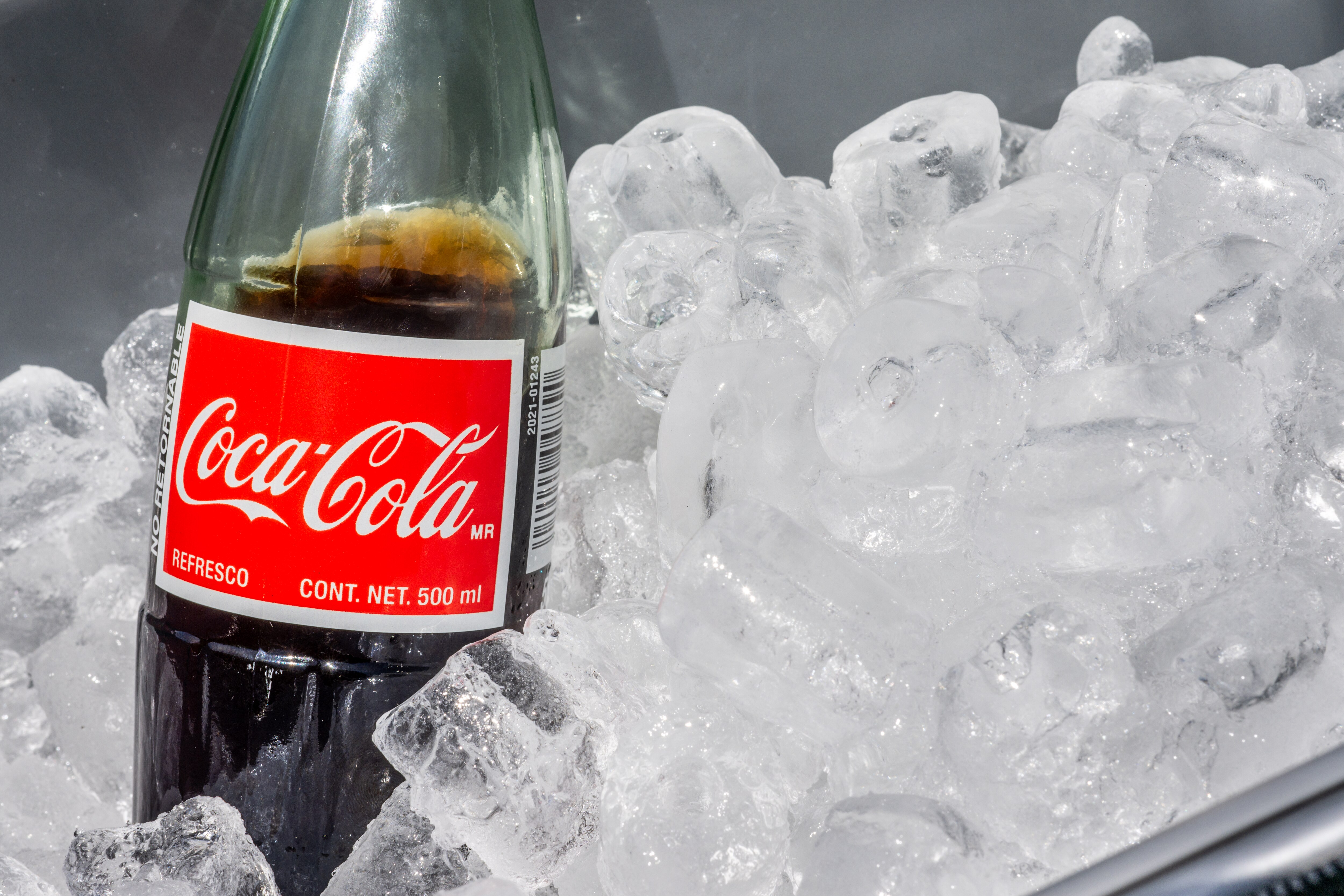 AUSTIN, TEXAS - JULY 17: In this photo illustration, a Mexican Coke beverage is displayed in an ice-cooler at a park on July 17, 2025 in Austin, Texas. U.S. President Donald Trump stated in a Truth Social post that Coca-Cola has agreed to use real cane sugar in its U.S. beverages, similar to Mexican Coke.