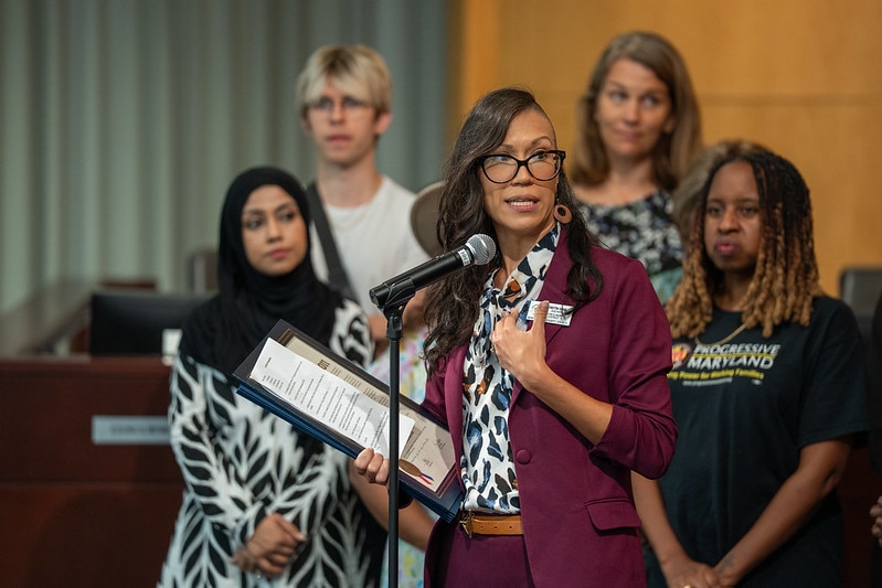 A woman reads a proclamation at an microphone.