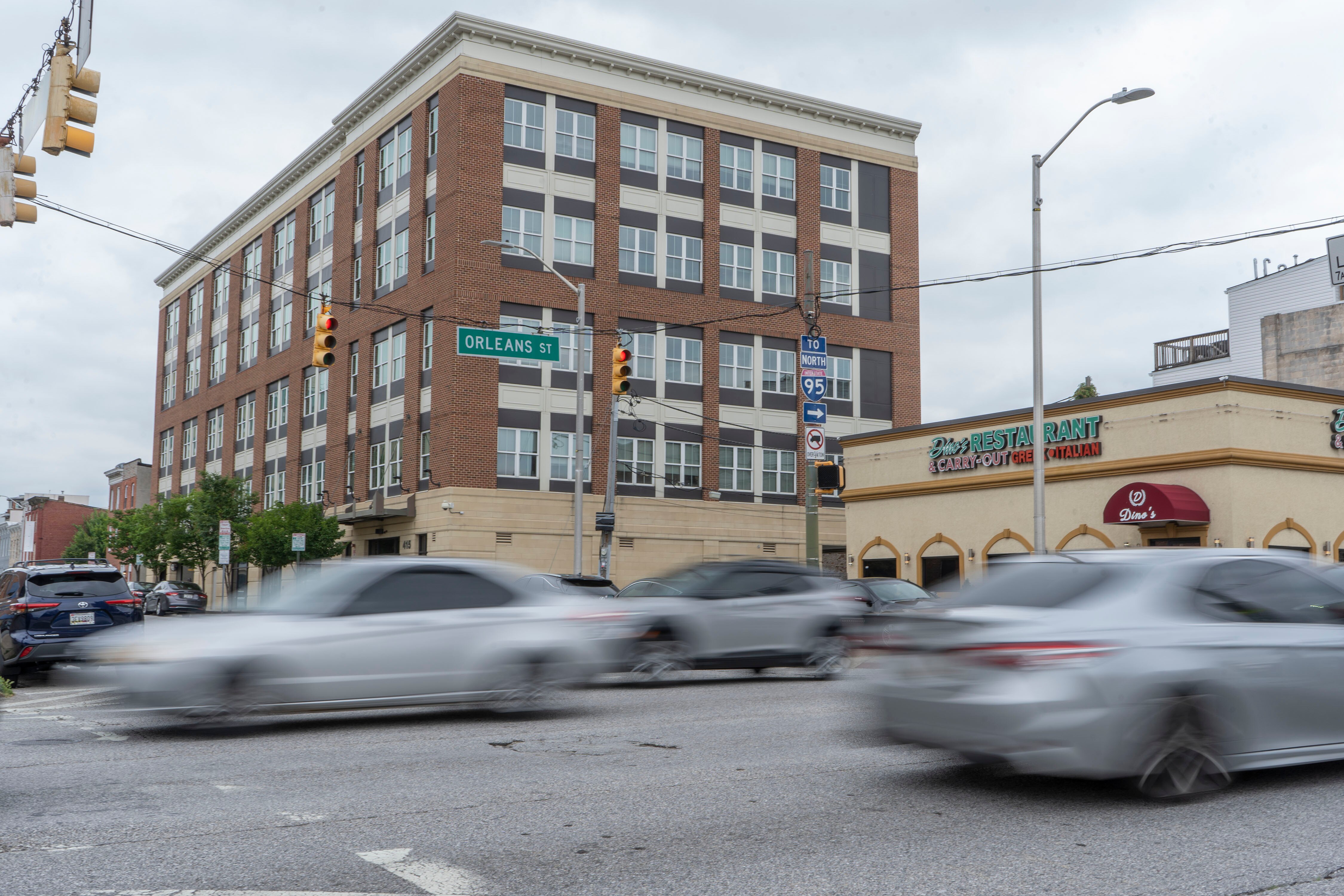 Cars drive on Orleans Street near the Johns Hopkins East Baltimore Campus.
