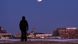 A man views the lunar eclipse, Tuesday, March 3, 2026, in South Portland, Maine.