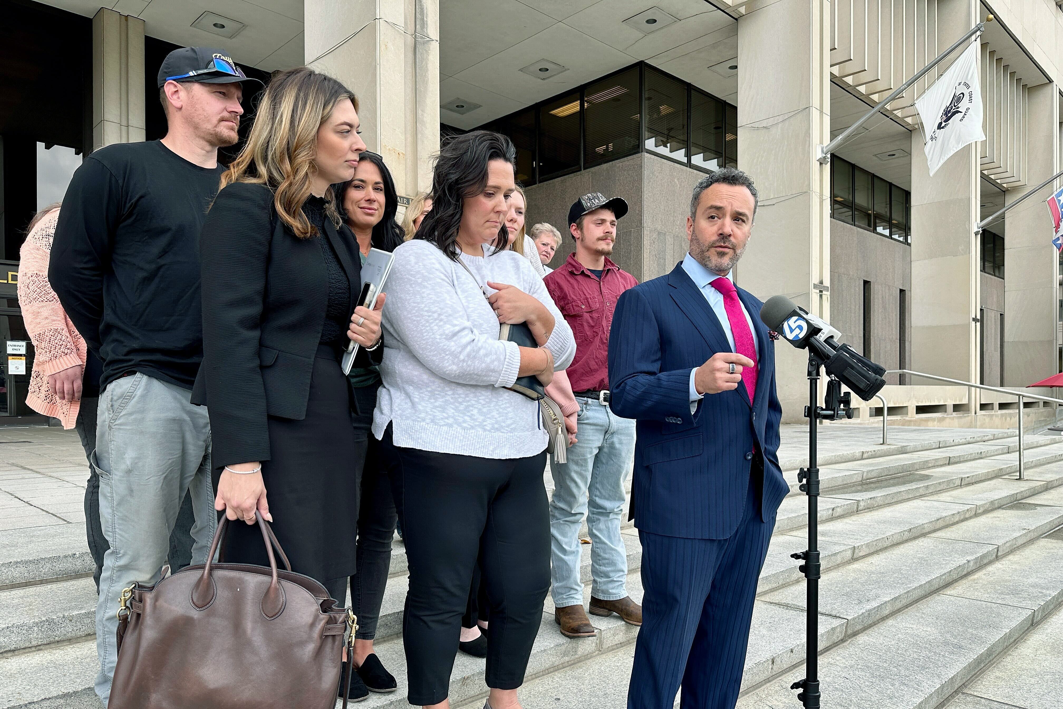 Defense attorney Jeremy Eldridge, surrounded by members of Dwight Rust Jr.'s family, addresses reporters outside the Baltimore County Circuit Court in Towson on Wednesday. A judge ordered Rust Jr. released on home detention while he awaits trial in the 2002 murder of his wife, Michelle.