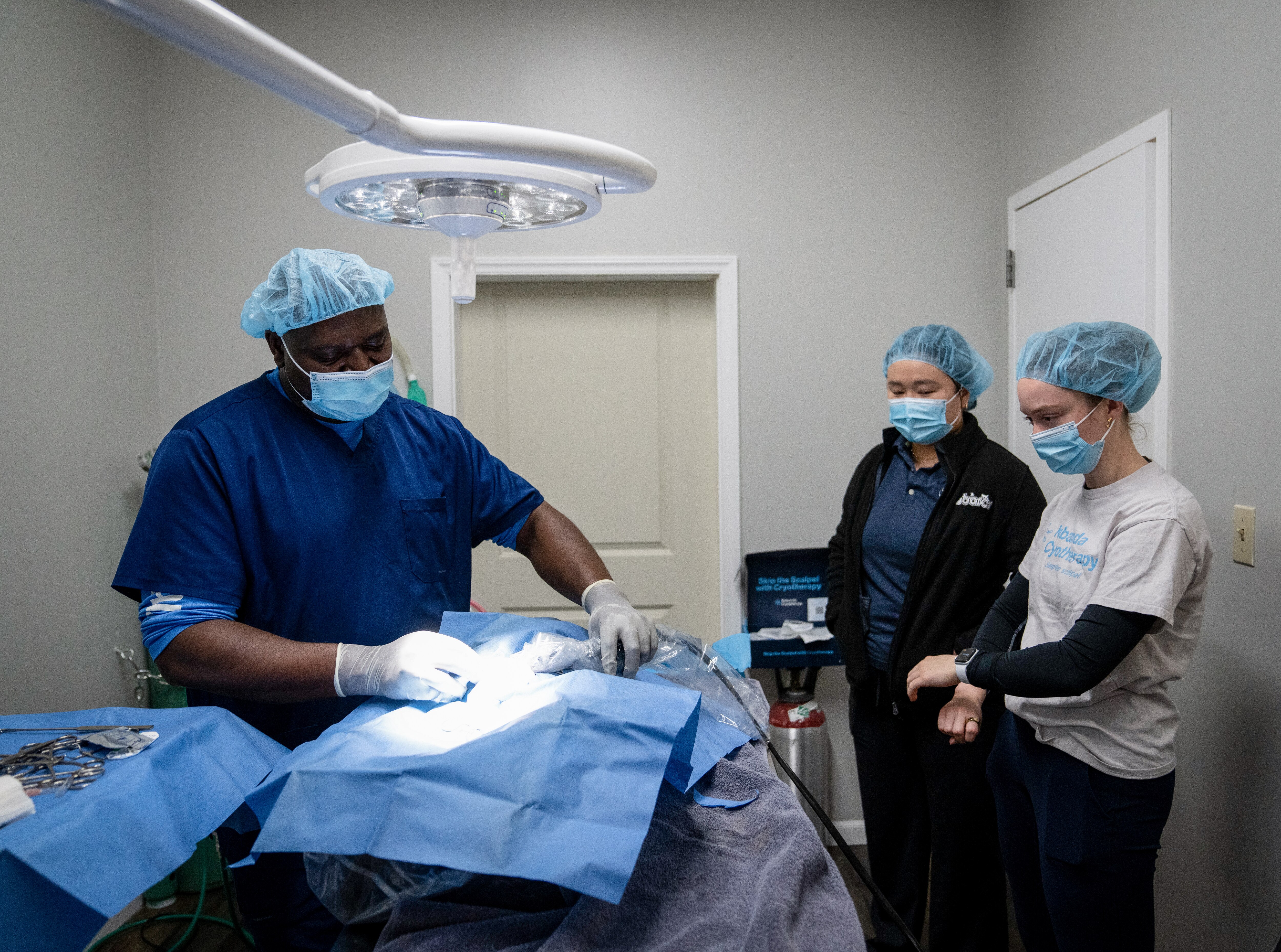 Dr. Salifou Bishop, left, uses cryotherapy to remove a tumor from a patient at Loving Pet Care Hospital in Baltimore, Md., on Thursday, January 2, 2024. He is joined by Clarisse Hu, Chief Technology Officer and co-founder at Kubanda, center, and Katie Ogg, clinical engineer for Kubanda,