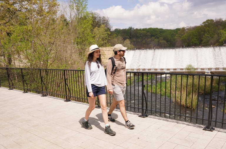 A couple walks across the bridge at Lake Roland Park trails after completing a hike.