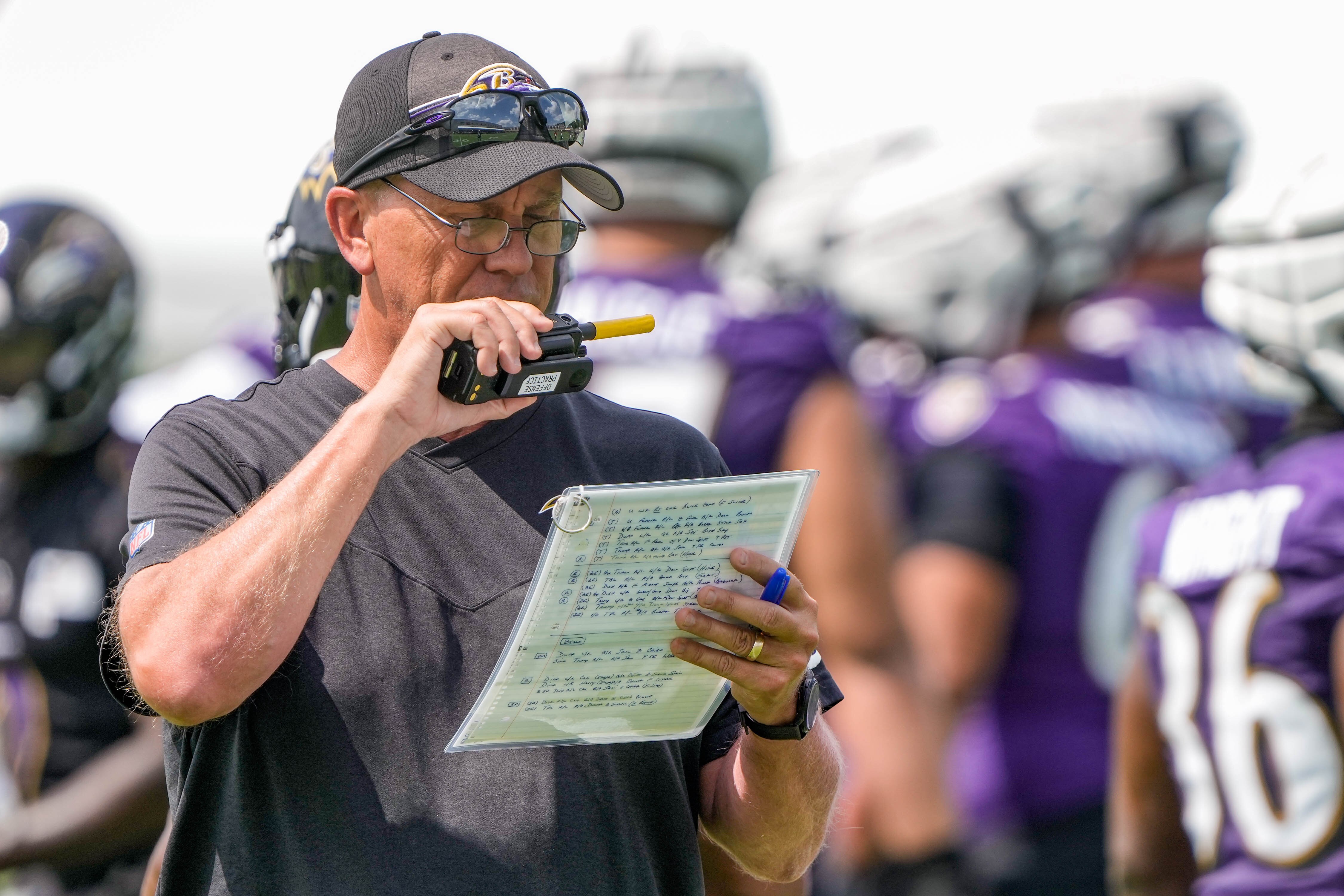 Offensive coordinator Todd Monken speaks into the radio at the first Ravens practice of the season Wednesday.