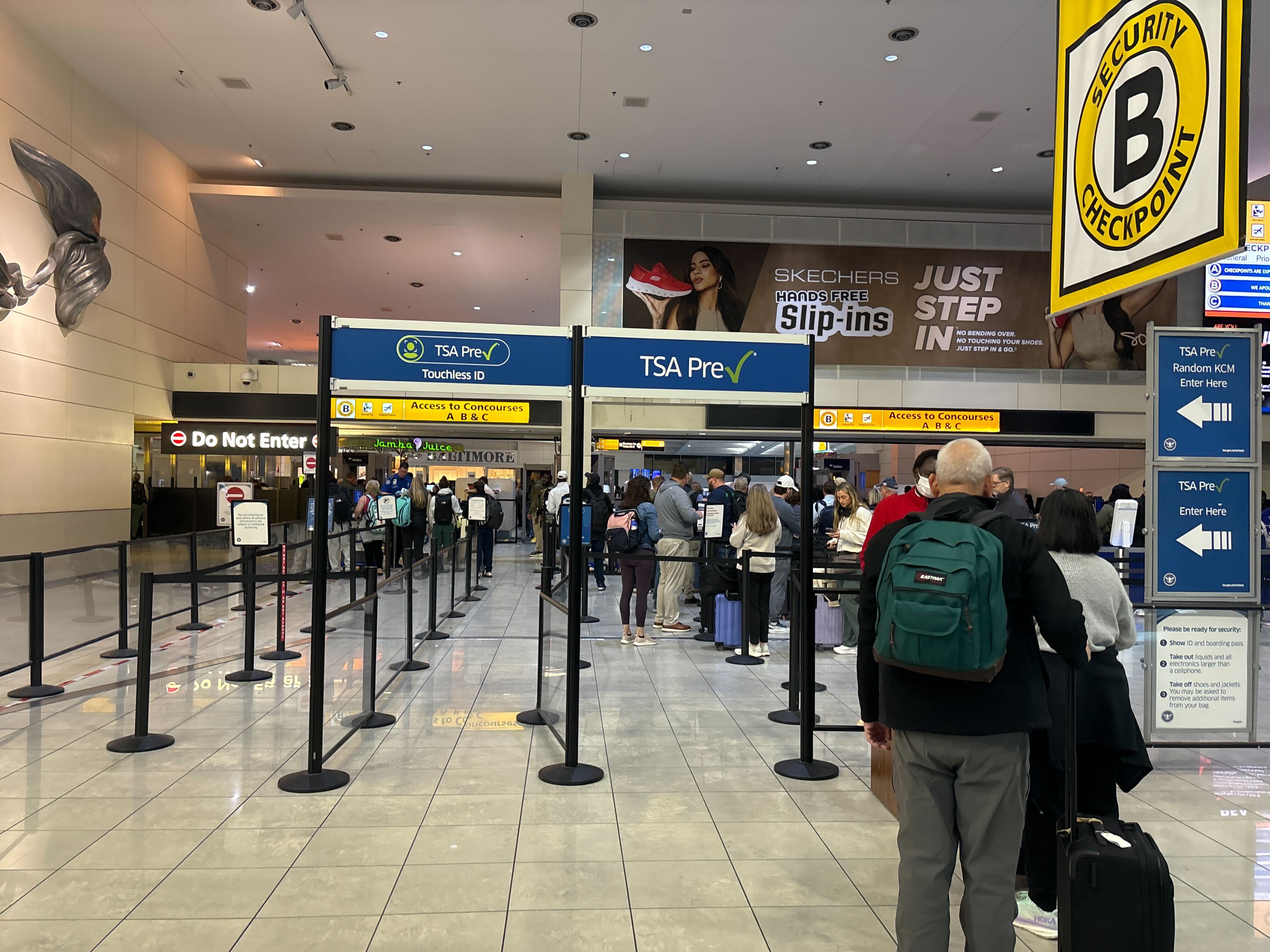 People stand in line at a security checkpoint at BWI Airport.