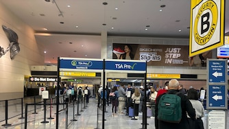People stand in line at a security checkpoint at BWI Airport.