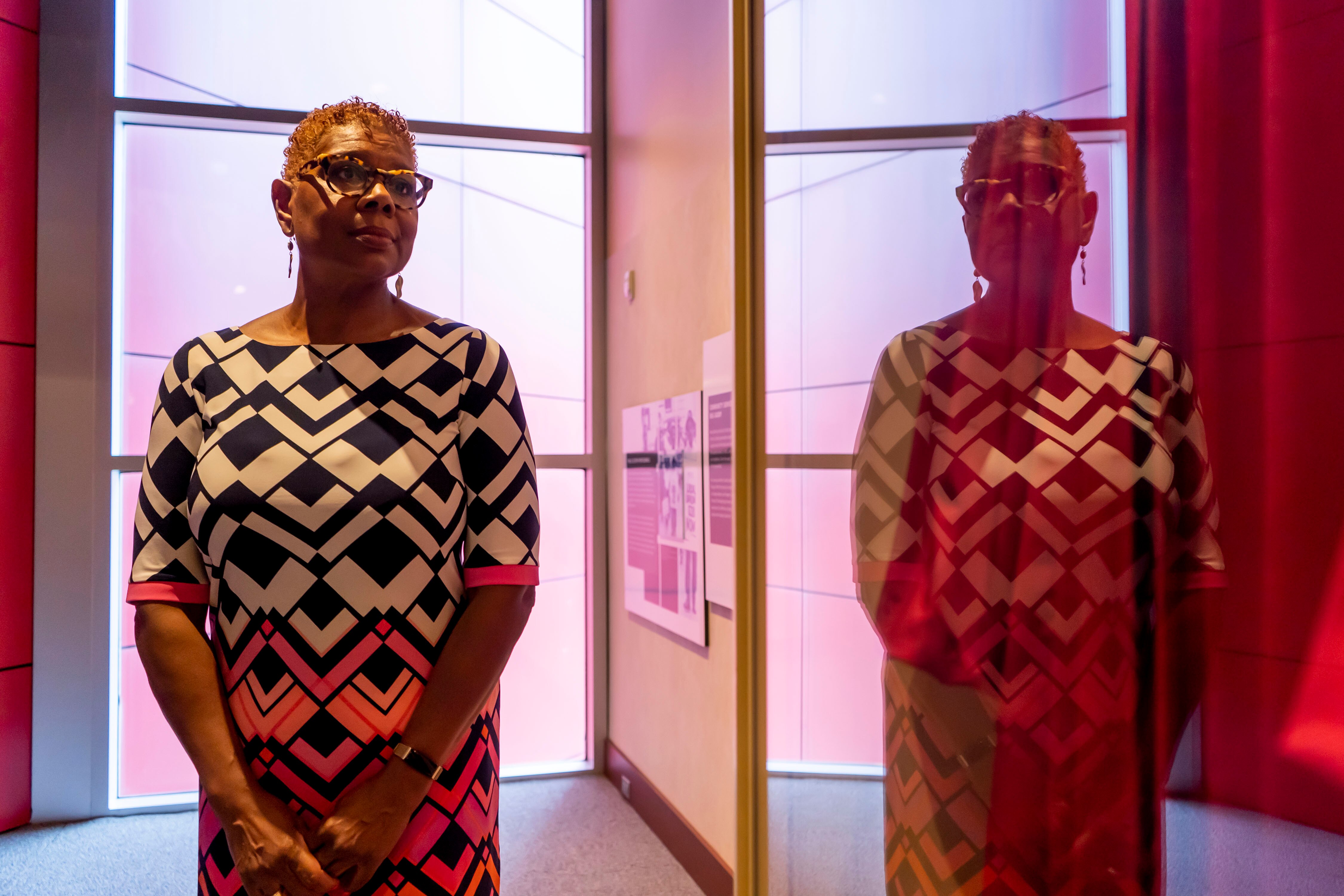 Terri Freeman, executive director of the Reginald F. Lewis Museum, in the reflection of Judge Robert Bell's robe in the museum's permanent exhibit.
