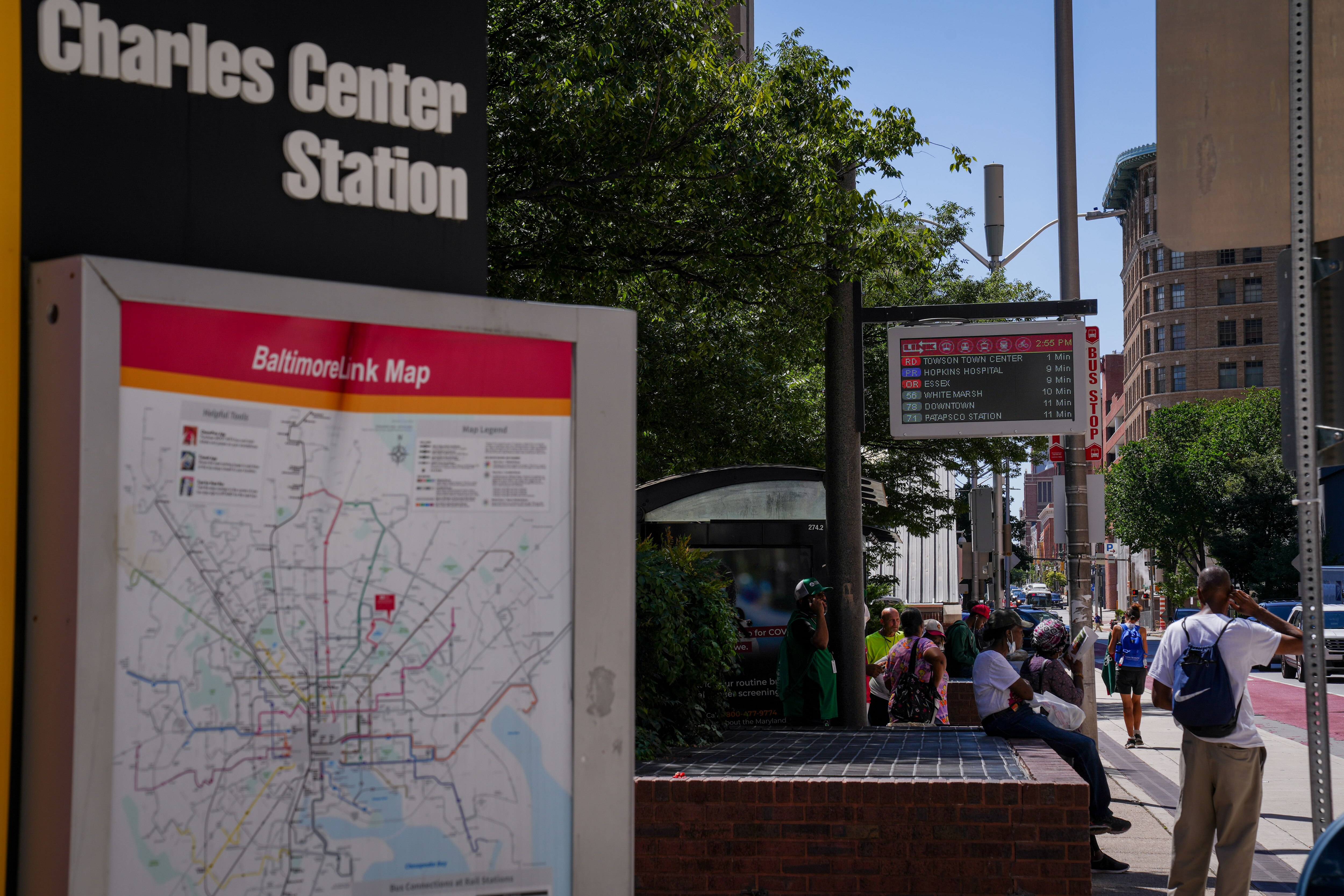 People wait for their bus to arrive outside Charles Center Station on Aug. 8, 2022.