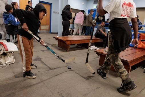 Junior Banners player Amir Wilson, 9, plays hockey in the lobby of the Mimi DiPietro Skating Center after the Rink Rally event.