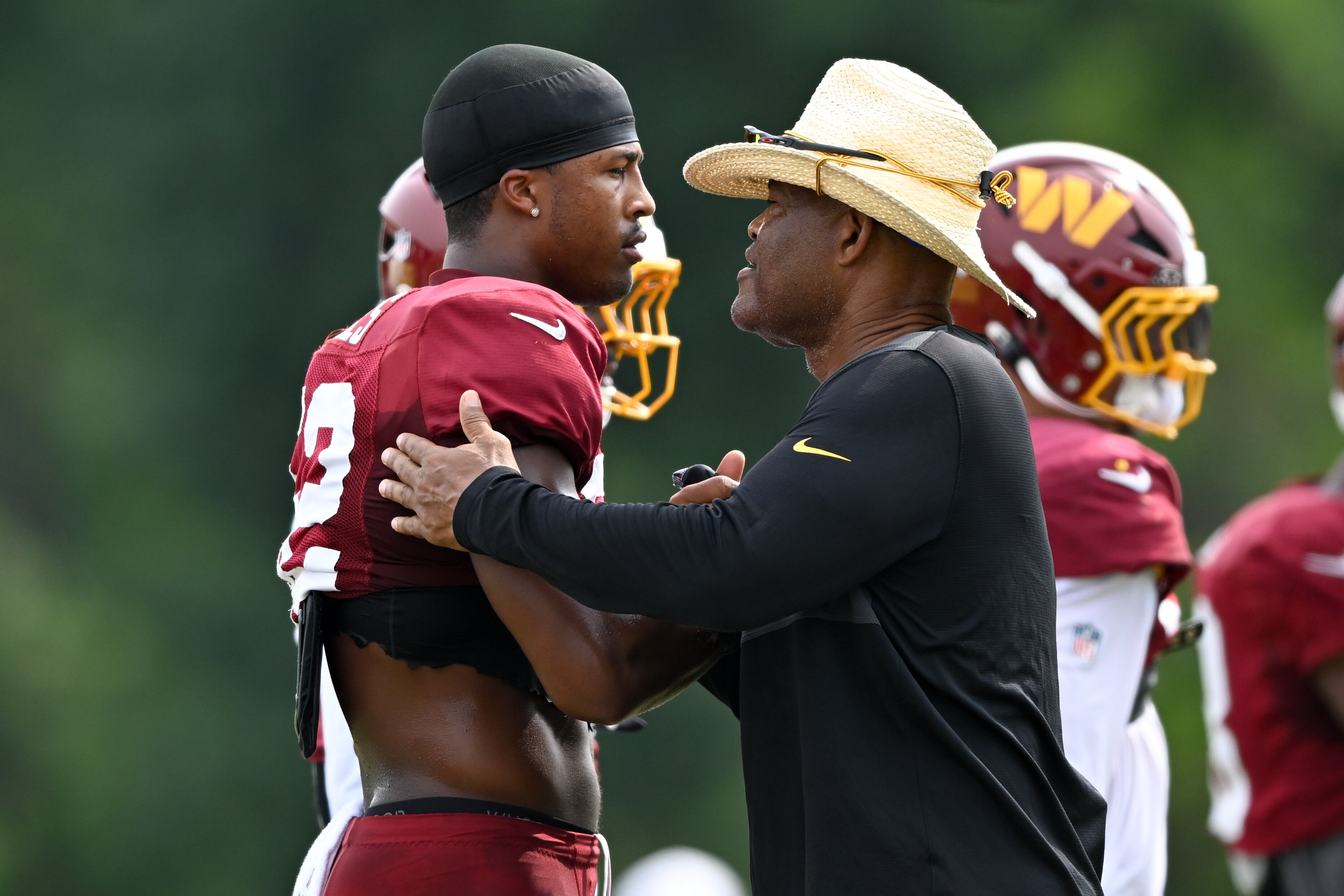 Commanders first-round draft pick Sonny Styles greets linebackers coach Ken Norton Jr. during training camp.