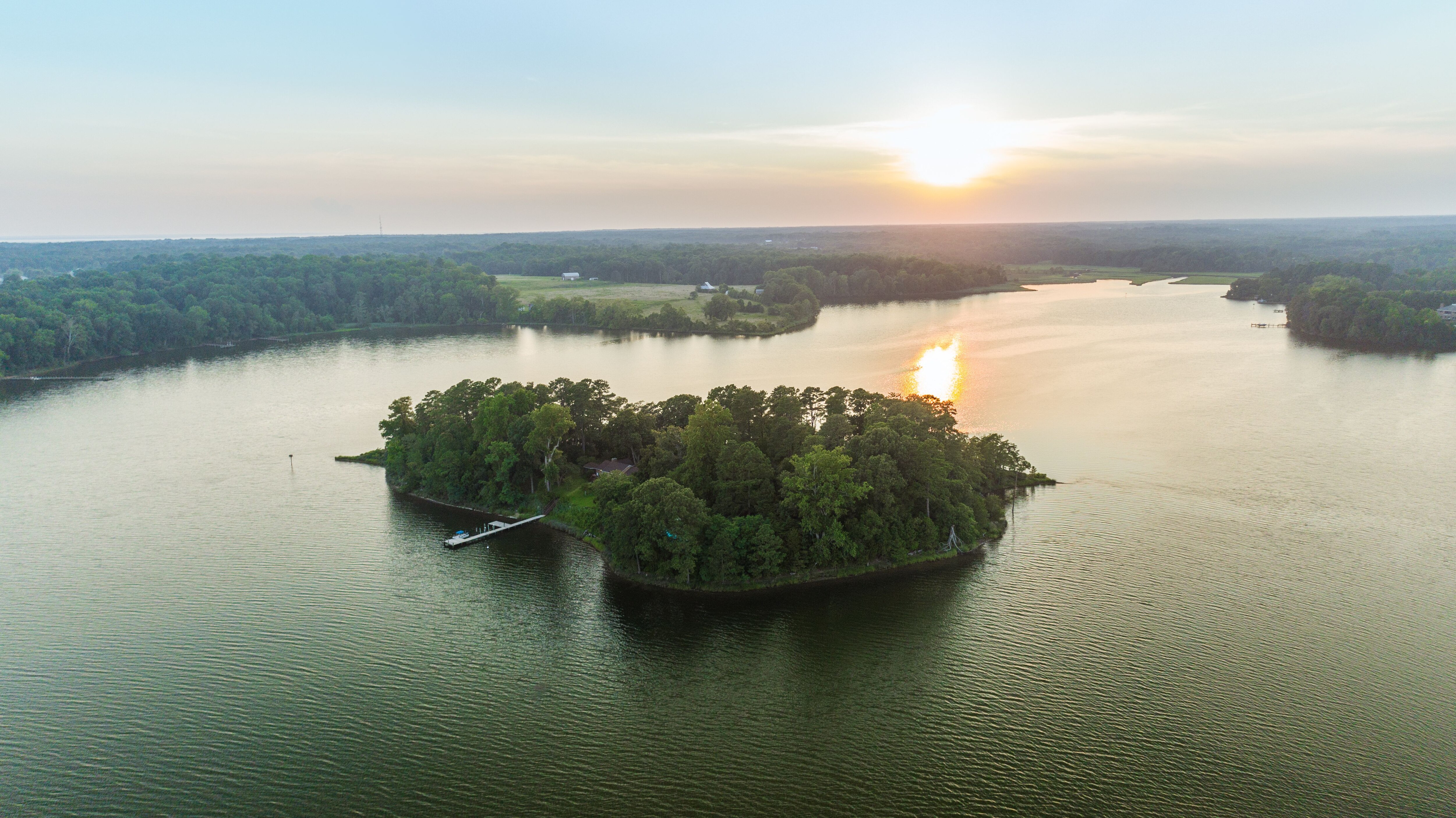 An aerial view of the island that shows the wooded areas and the dock.