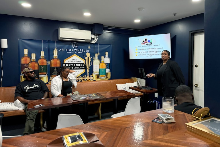 Cortnie Burriss hosts a game night every first Thursday of the month at Upper Marlboro’s Free State Distillery. Patrons play “Talk Your Suit,” a game Burriss originally created for her high school literature students and encourages players to use different conversation skills.