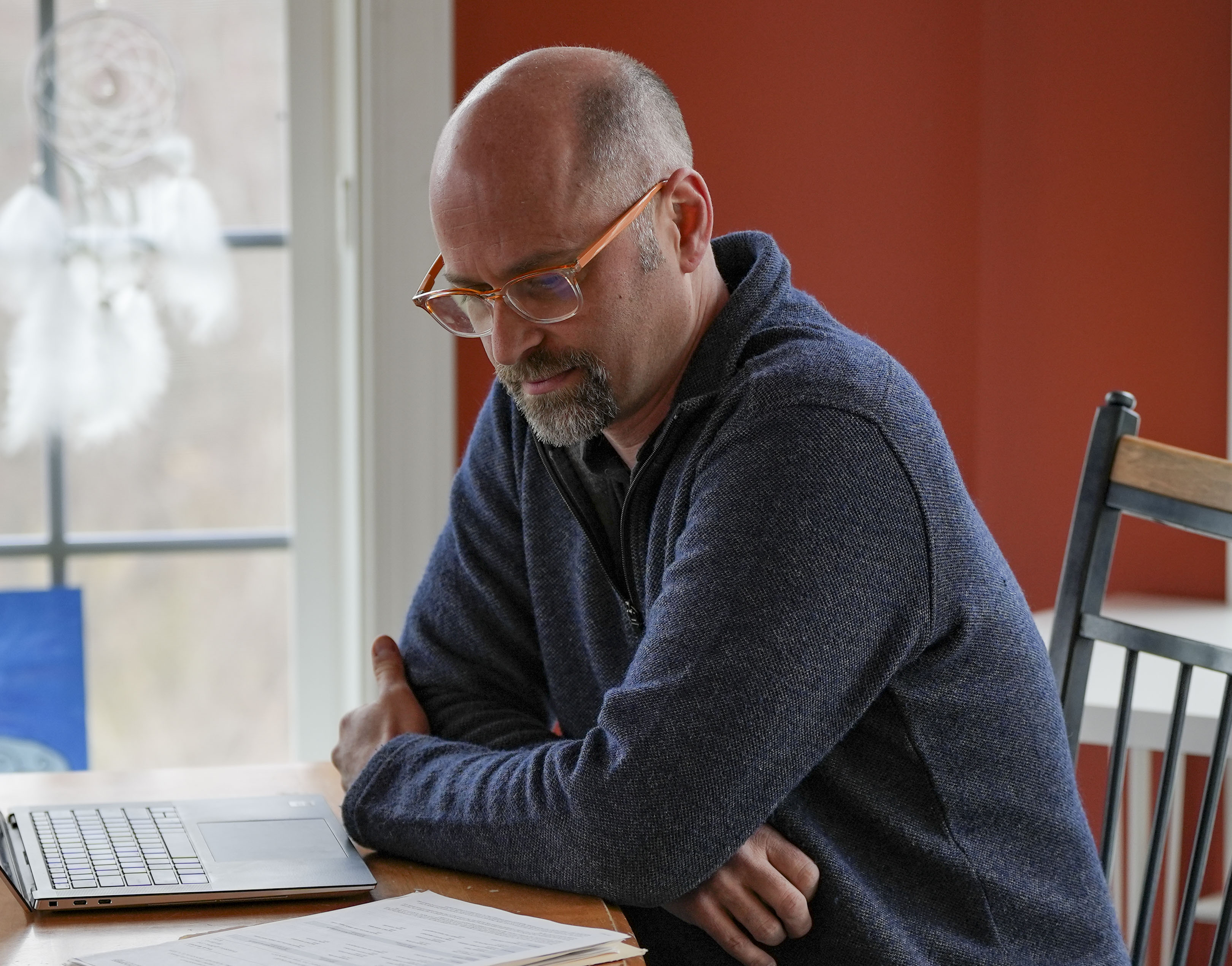 Eric Marshall, sits at his dinner table reviewing his 529 program folder to find documentation supporting his claim of the money he is owed after almost 2 decades of saving for his kids college tuition from Clarksburg, MD, on March 11, 2023.