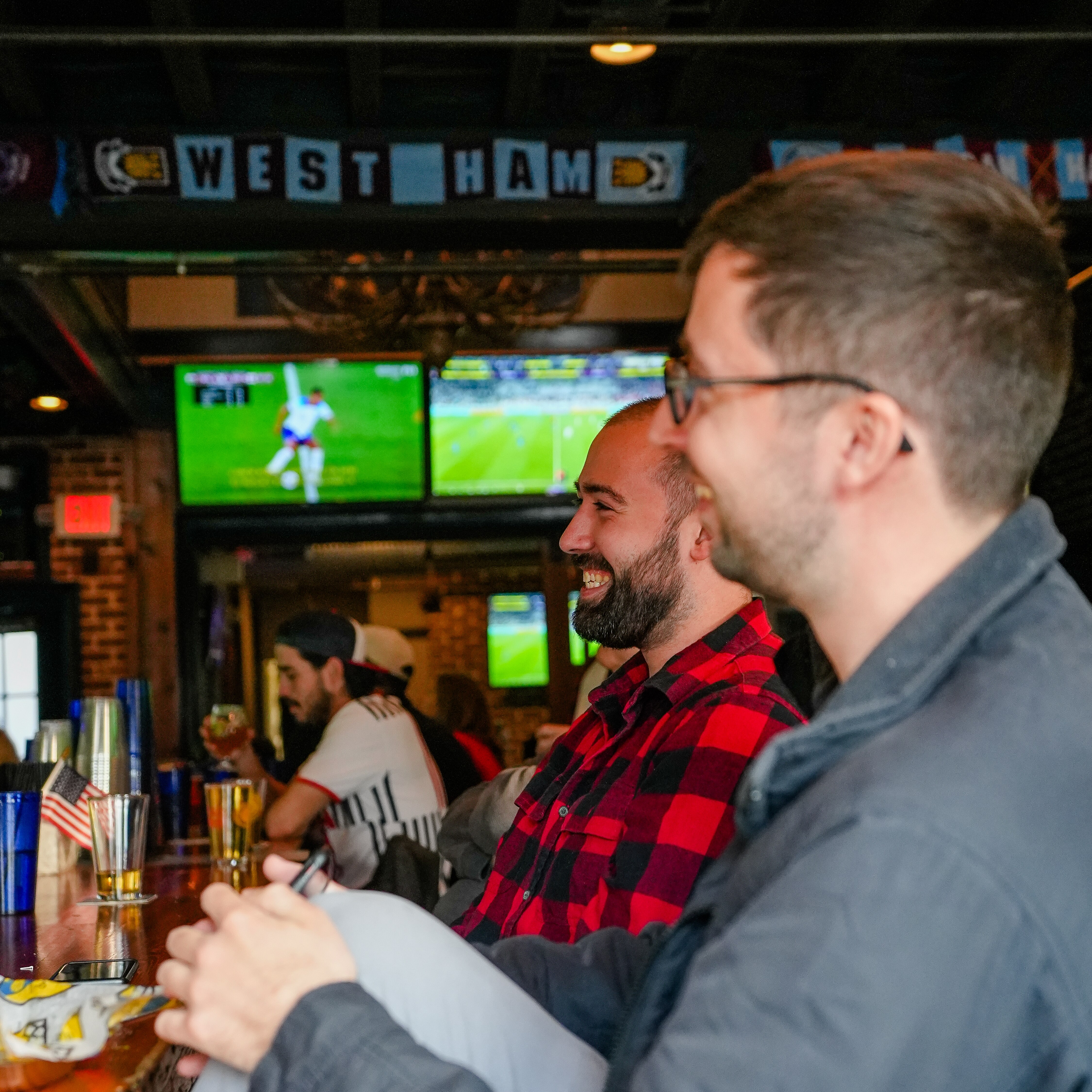 Brothers, Joey Fluehr, 24, (left) and Ryan Fluehr, 29, share some good laughs while watching the USA vs. Iran World Cup match at Abbey Burger in Little Italy, Baltimore, Md., on November 29, 2022.