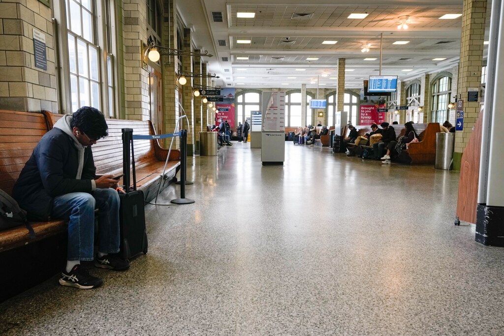 Travelers wait for their trains at Penn Station in Baltimore, Md., on Monday, January 26, 2026.