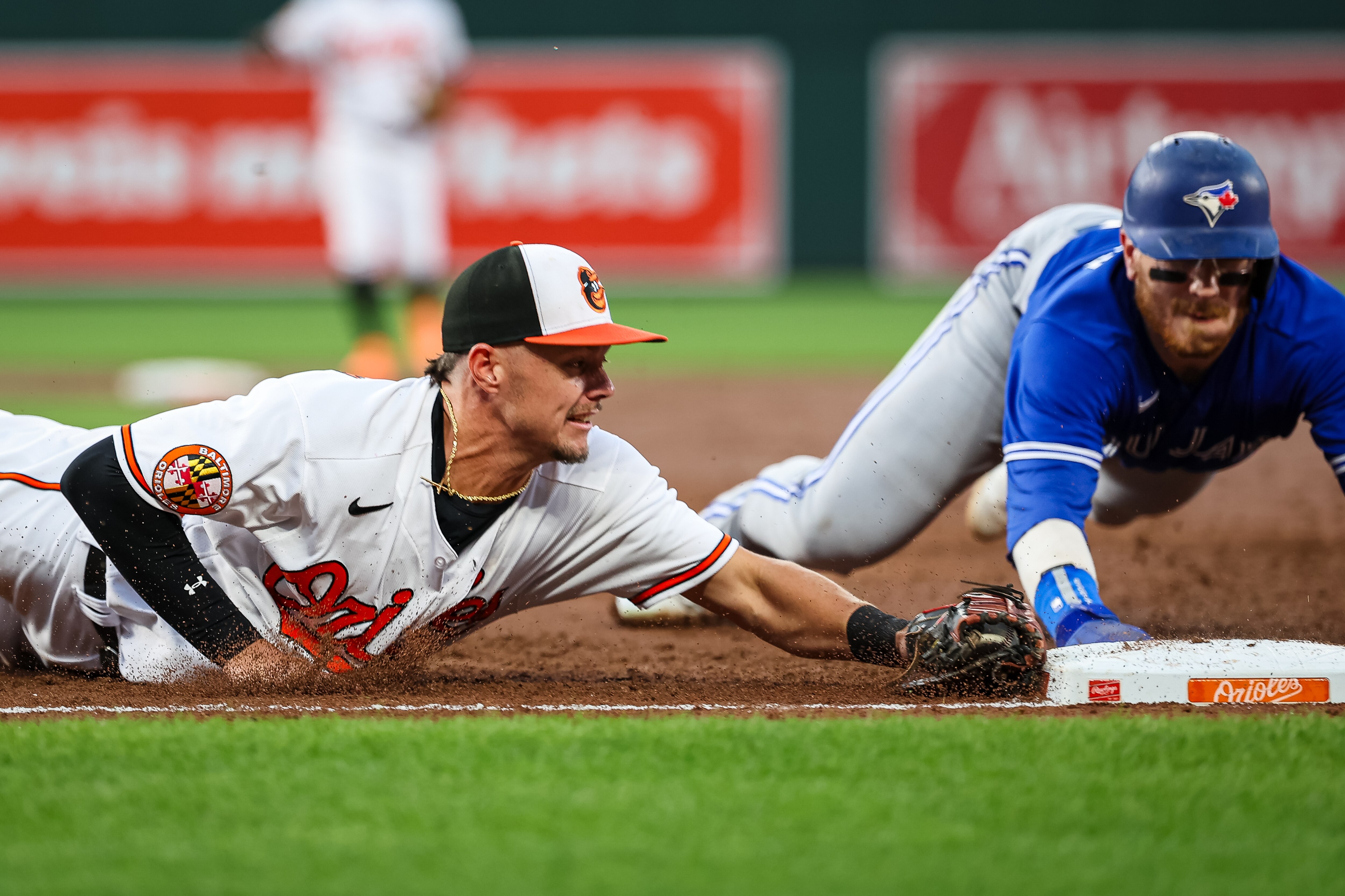 Ryan Mountcastle #6 of the Baltimore Orioles dives to retire Danny Jansen #9 of the Toronto Blue Jays at first base after catching a line drive hit by Kevin Kiermaier #39 during the second inning at Oriole Park at Camden Yards on August 22, 2023 in Baltimore, Maryland.