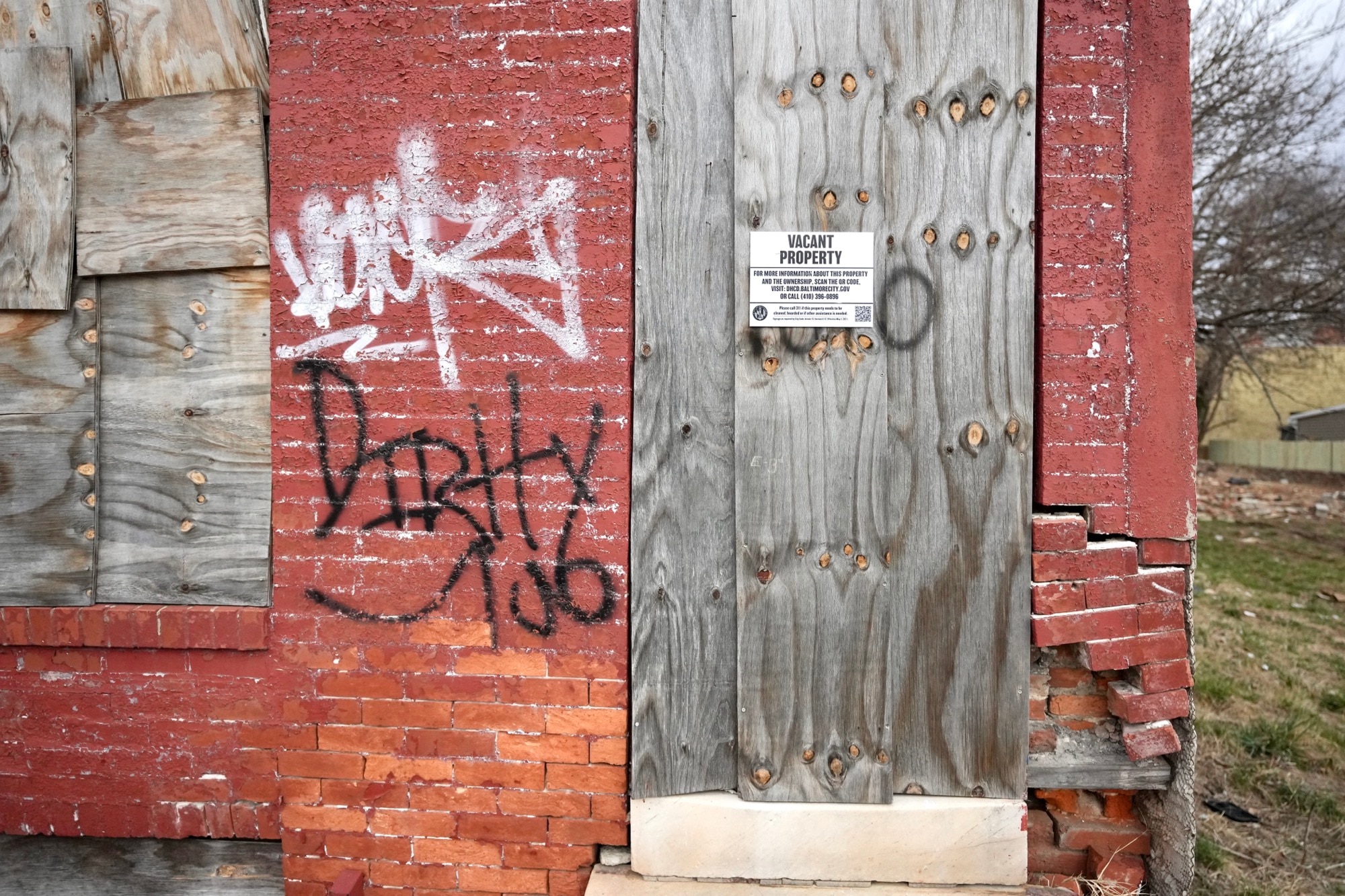 Mayor Brandon Scott speaks outside of vacant homes on West Saratoga street during a press conference hosted by Build One Baltimore on February 16, 2023.