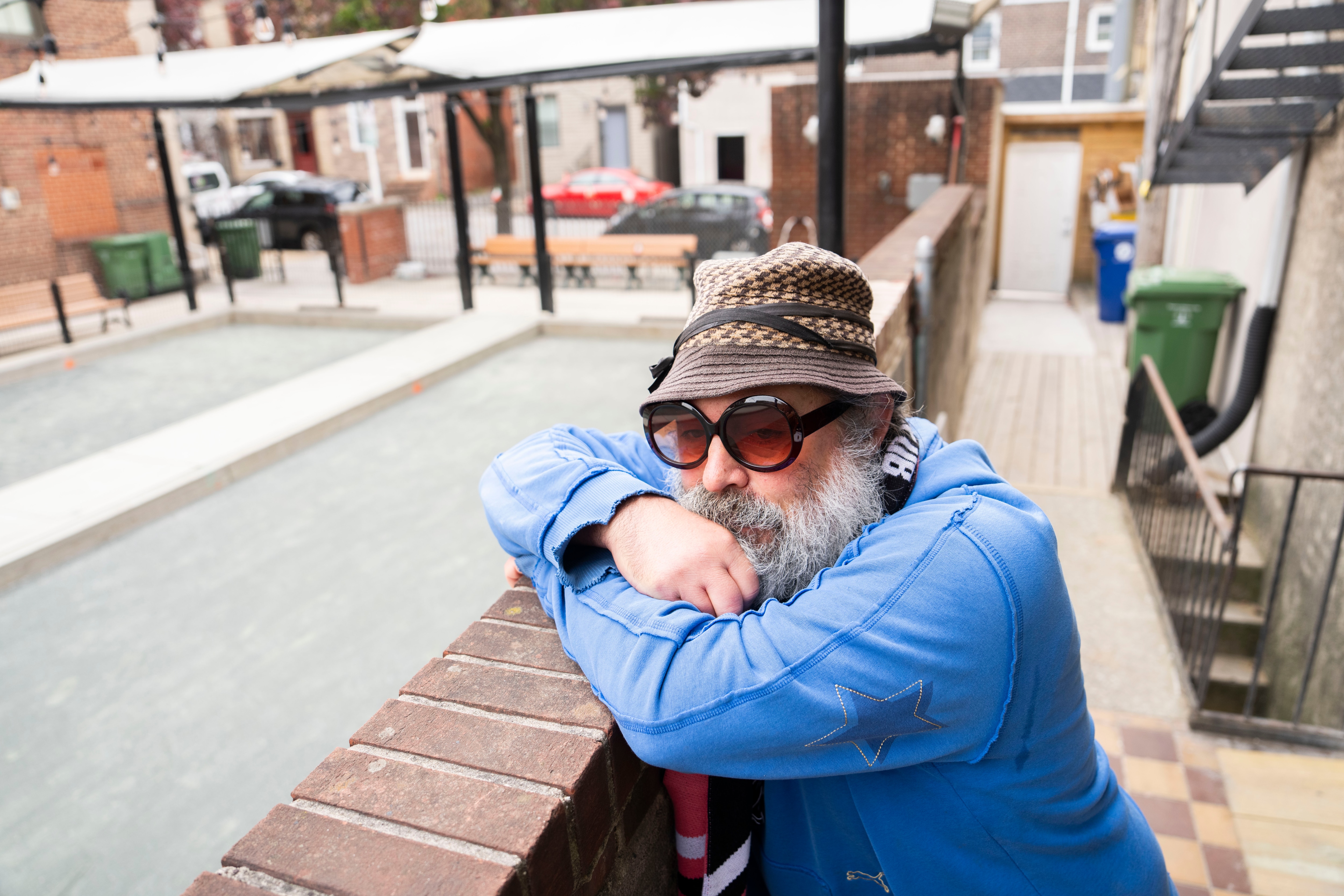 William Bauer, better known as Lou Catelli, overlooks the bocce ball court behind the new space of MFG Toffee & Bark Co. in Baltimore’s Little Italy.