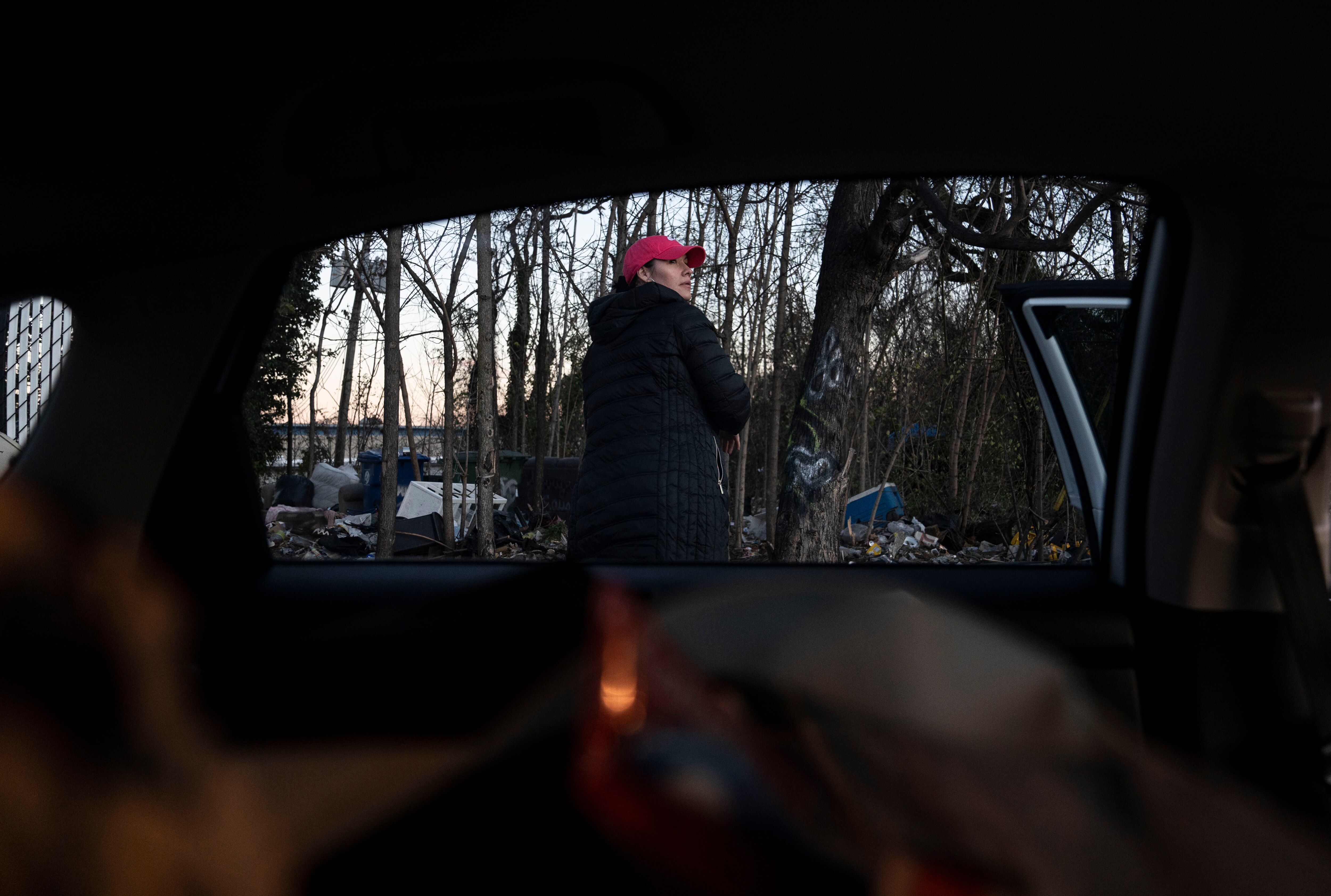Kristina Page looks behind a gas station lot to see if anyone is in need of supplies, in Baltimore, Thursday, December 5, 2024.