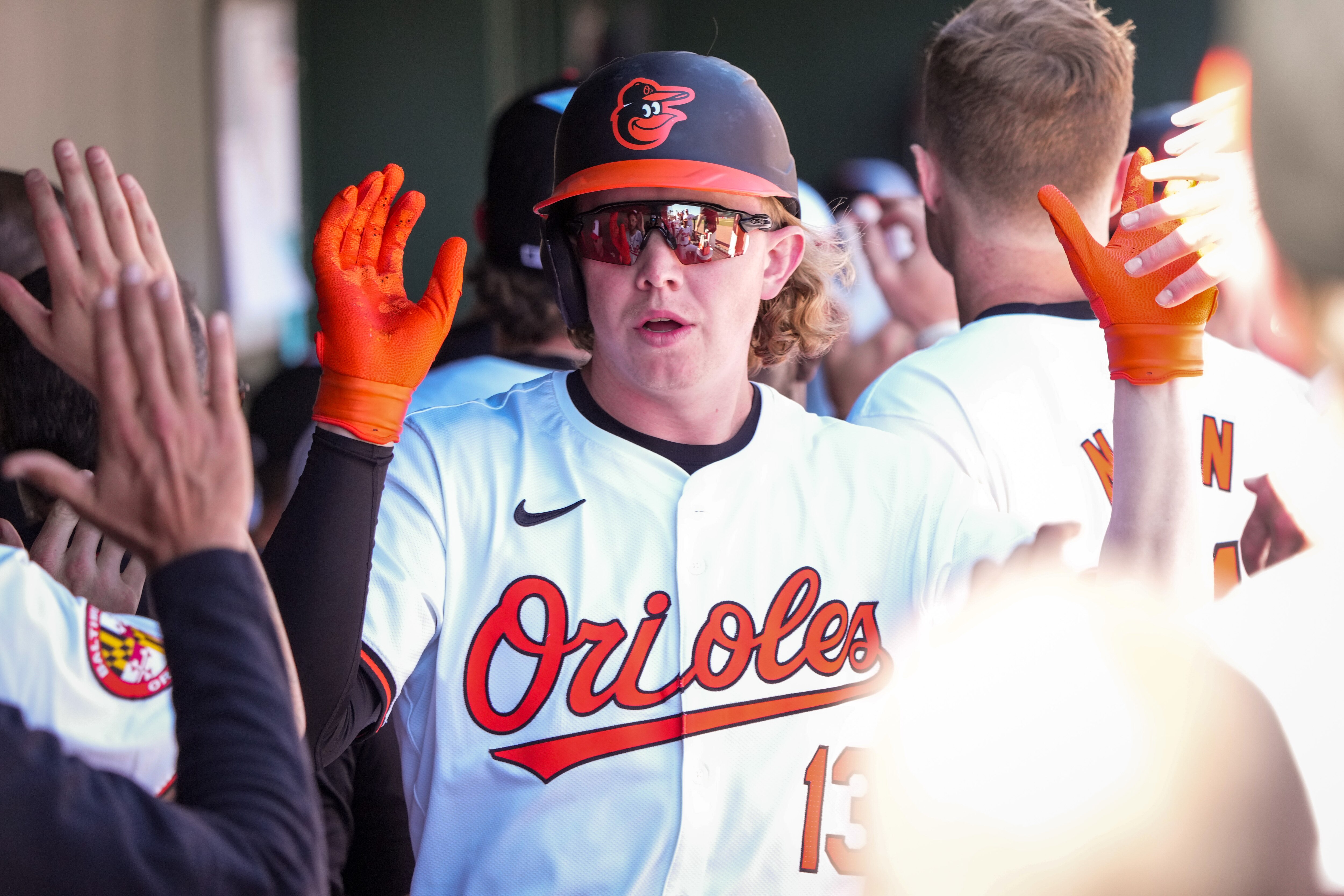 Baltimore Orioles right fielder Heston Kjerstad (13) high-fives teammates after scoring a run during a Grapefruit League game in February. He’s expected to join the Orioles for Tuesday’s game against the Angels.