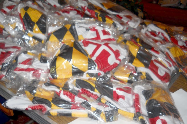 A pile of Ali Von Paris’ Maryland State flag bikinis lies on her parent's table. The bathing suit's popularity inspired Von Paris to make the Maryland state flag a central aspect of her company's merchandise.