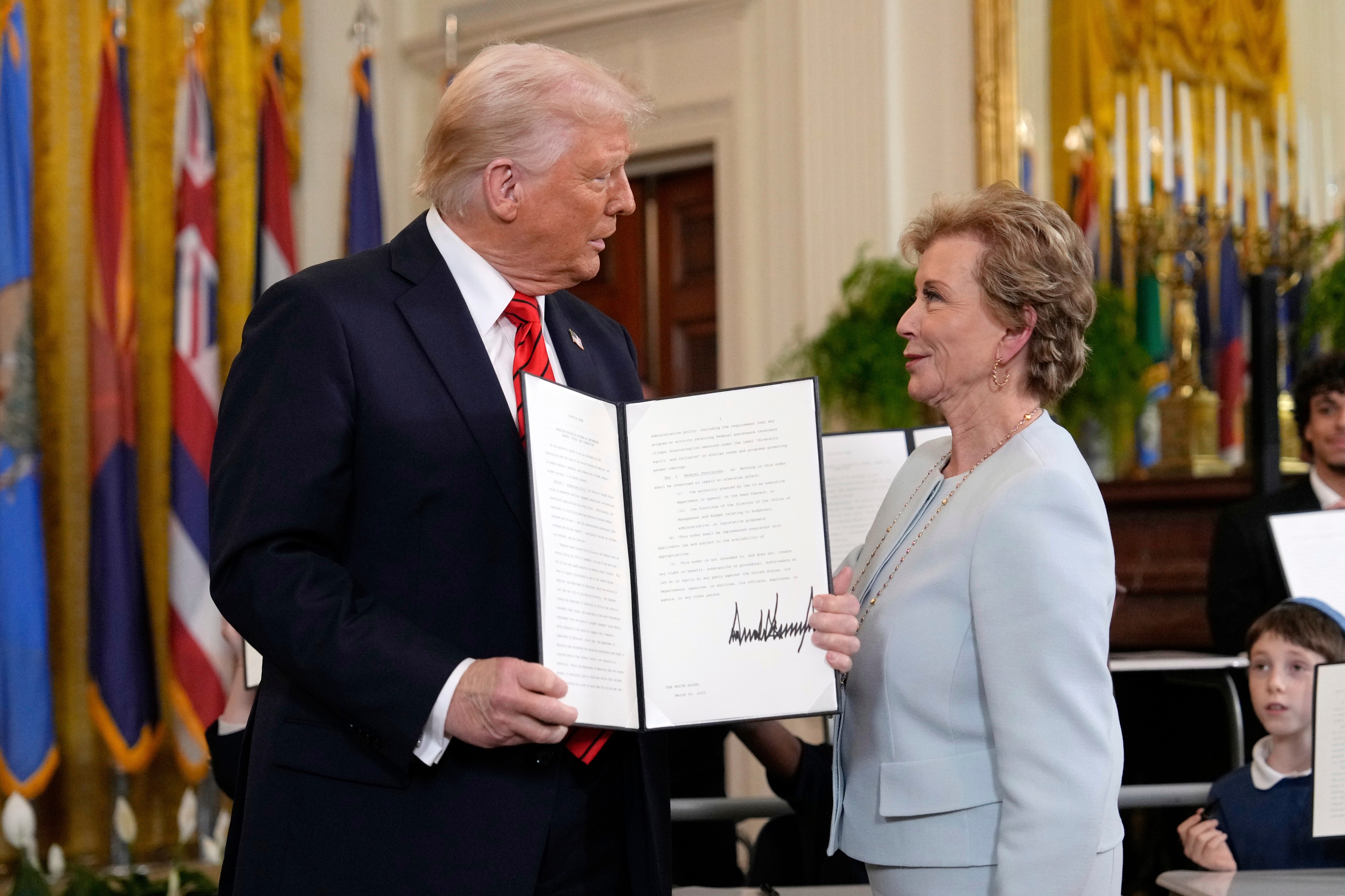 President Donald Trump holds up a signed executive order alongside Secretary of Education Linda McMahon in the East Room of the White House in Washington, Thursday, March 20, 2025.