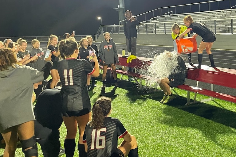 Crofton soccer coach Jason Bonfigli (sitting) gets a celebratory water dumping after Friday's overtime victory over Towson. The Cardinals, in its second varsity season, advanced to the Class 3A state semifinals with a 1-0 decision in Anne Arundel County.