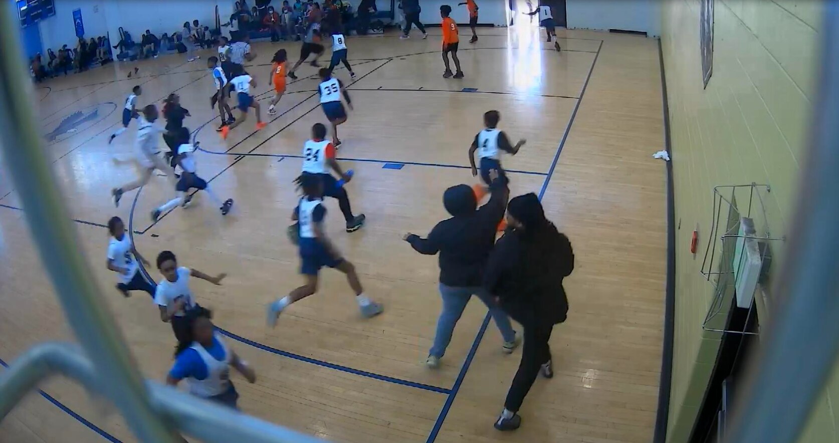 A still from gym security camera footage shows the first moments of an altercation at a Leith Walk Elementary Middle School basketball game on March 6, 2023 between a player's father and one of the team's coaches.